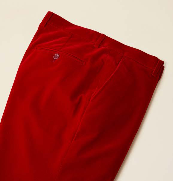 The Inserch Velvet Pants P502-30 in red, from the brand Inserch, showcase a modern fit and are crafted from luxurious velvet fabric. Gracefully displayed on a plain surface, these pants feature a single back pocket with a button, effortlessly blending style and comfort.
