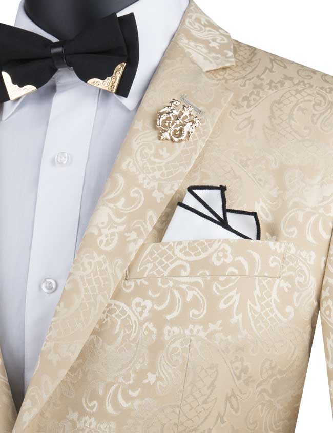 The Vinci Suits Slim Fit 2 Piece Single Breasted Suit in Beige (S2F-1) features a luxurious wool feel, paired with a gold lapel pin, white shirt, black bow tie, and folded pocket square.