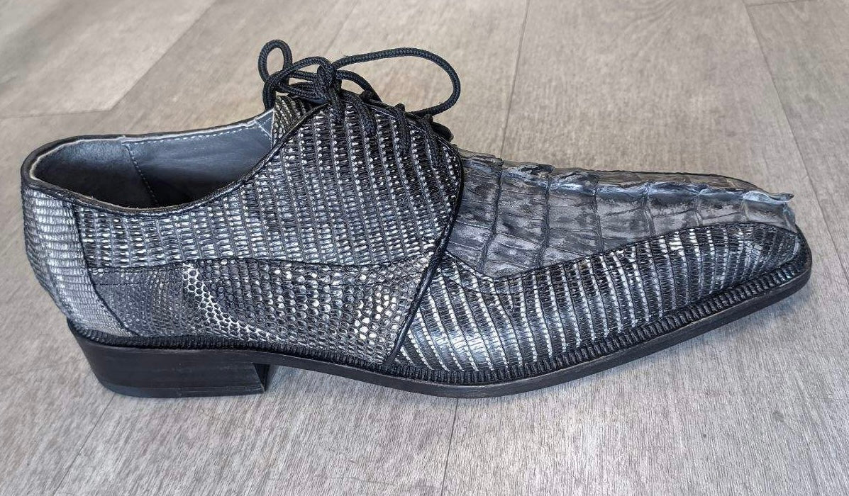 The Romano by Los Altos, a black and gray textured dress shoe crafted with genuine croc, featuring laces, is elegantly displayed on a light wood floor.