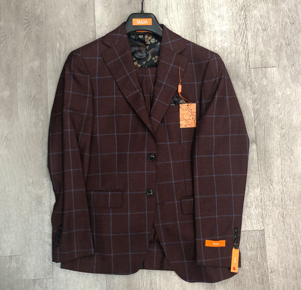 Tallia Brick and Blue Window Pane Suit Jacket (Size 38S only), featuring a window pane pattern, is showcased on a hanger against a light wood background. Orange tags accentuate the sleeve and label, emphasizing its unique style.
