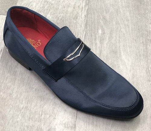 A sophisticated solid navy formal shoe made from premium satin with a buckle detail rests gracefully on a light wood floor, showcasing the quality of UNIQUE DESIGN MENSWEAR.