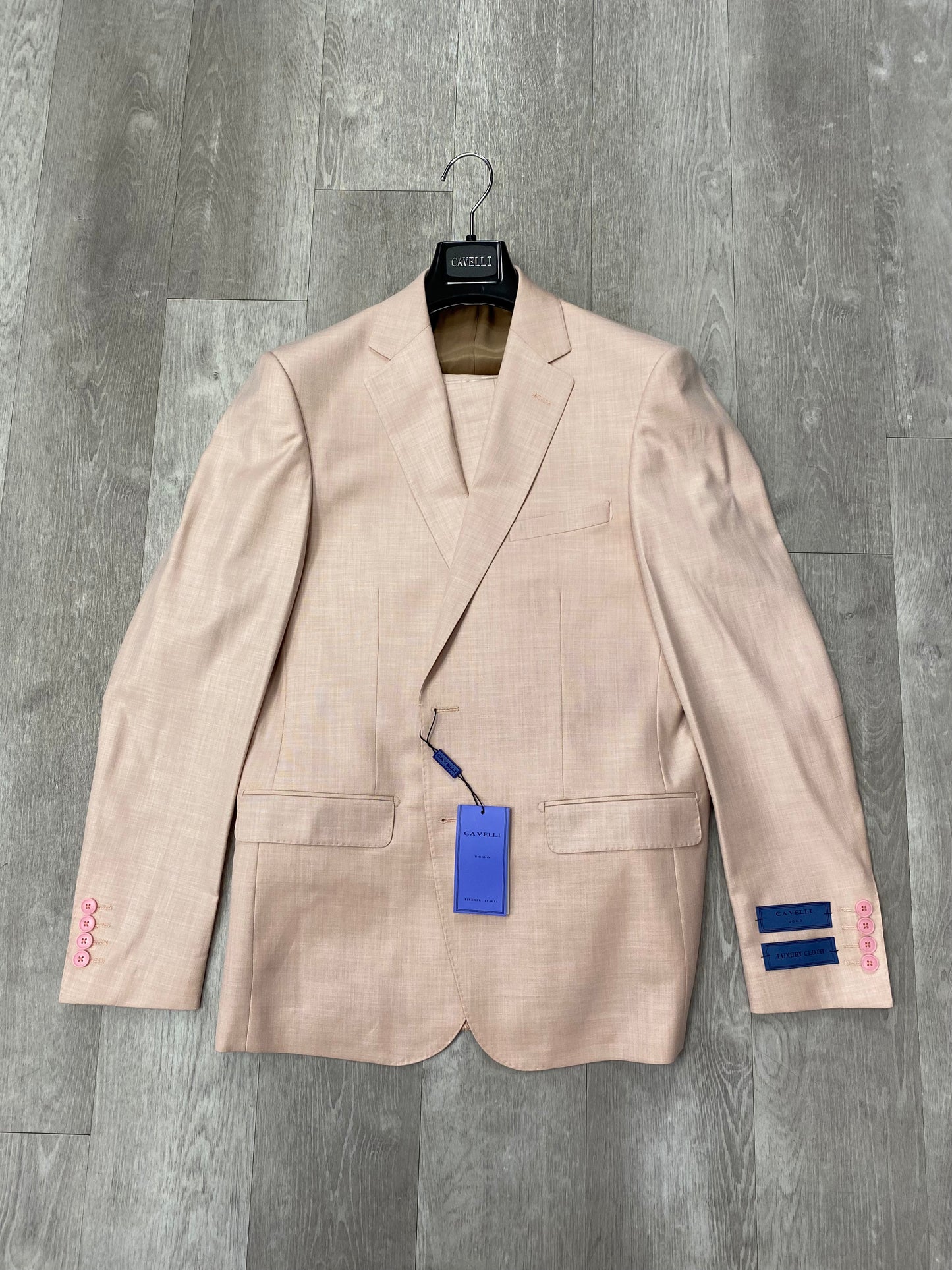 The Cavelli Uomo Porto SLIM FIT Suit 1986/16 in Dark Blush by CAVELLI features pink sleeve buttons and two blue stripes on the right cuff, combining lightweight comfort with modern style. FINAL SALE—NO RETURN OR EXCHANGE.