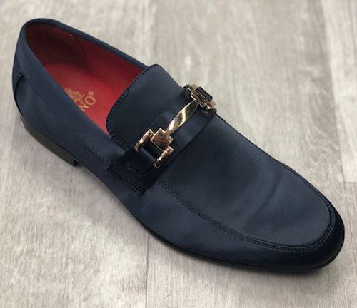 A single navy loafer from UNIQUE DESIGN MENSWEAR, crafted with exclusive satin and featuring a gold buckle detail, elegantly placed on a wooden floor.
