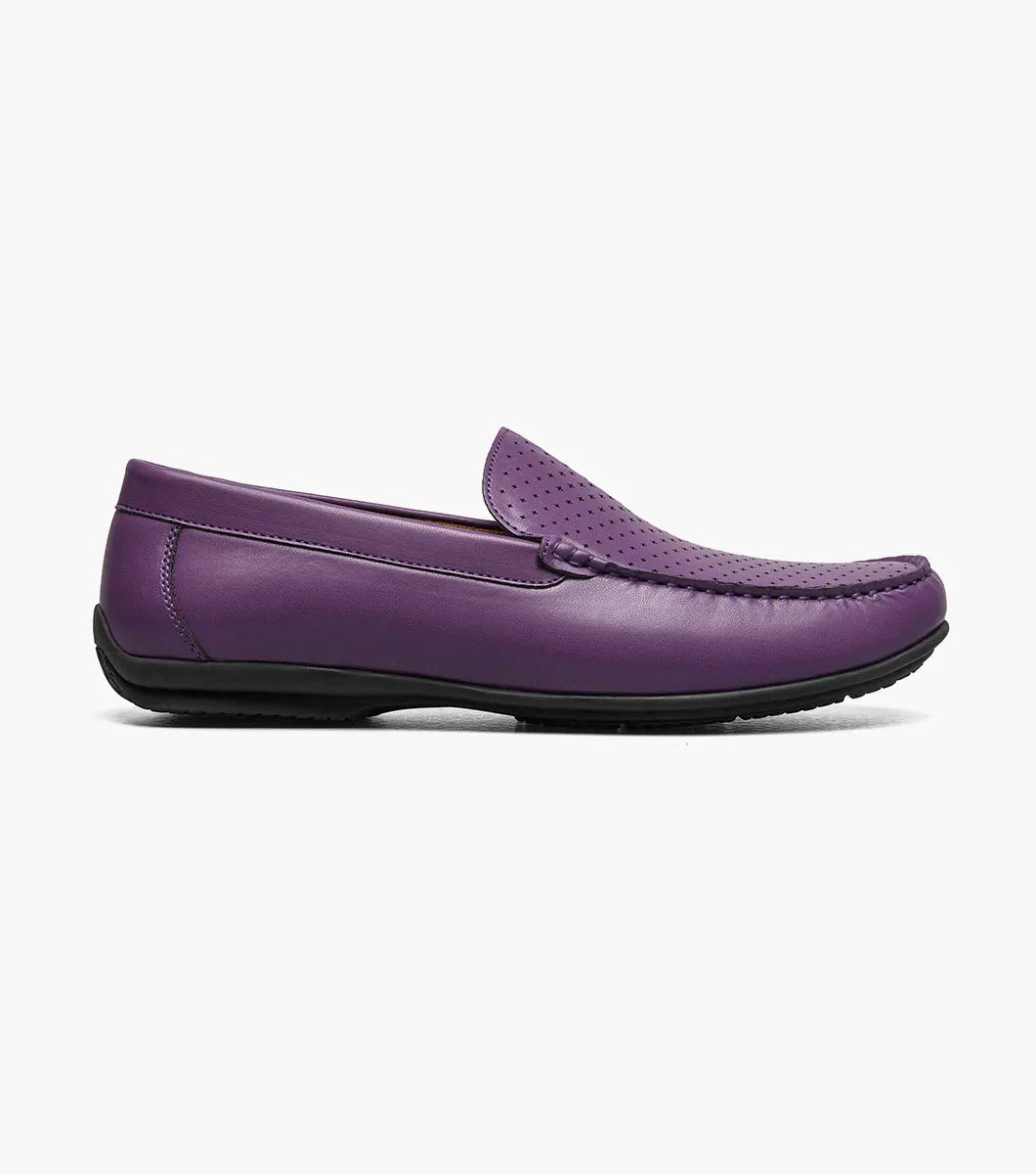 The STACY ADAMS Conroy Moc Toe Perf Slip On in purple (25702-542) features a perforated leather upper, cushioned footbed, black sole, and slip-on design, shown against a plain white background.