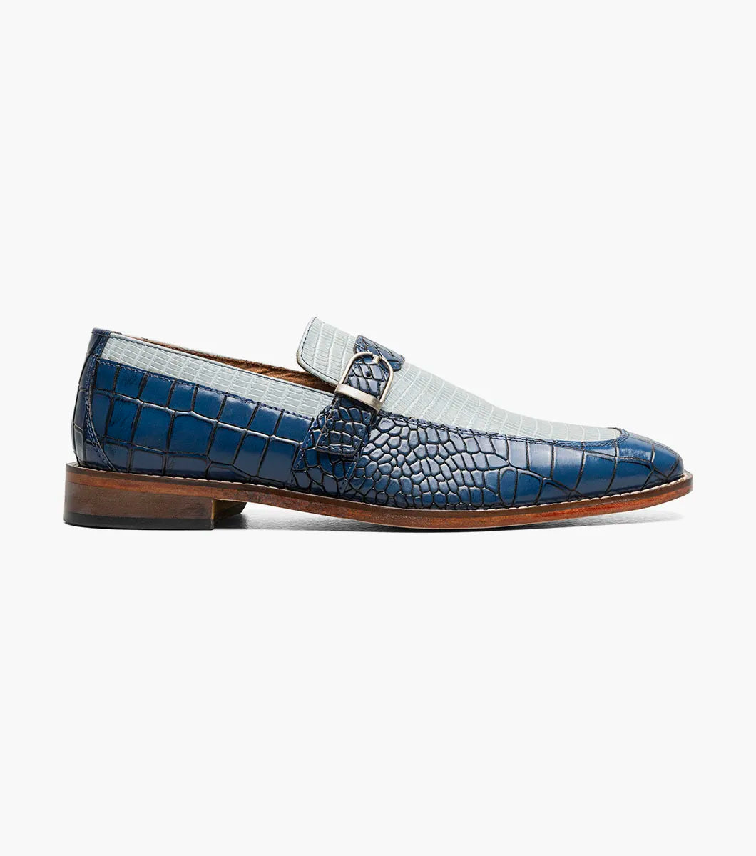 Introducing the STACY ADAMS Rubiano Moc Toe Buckle Strap Slip On in Dark Blue Multi (Style 25787-469)—a men’s loafer featuring a striking blue crocodile print leather overlay, a gray patterned upper, a moc toe slip-on design, side buckle strap detail, and a brown sole.