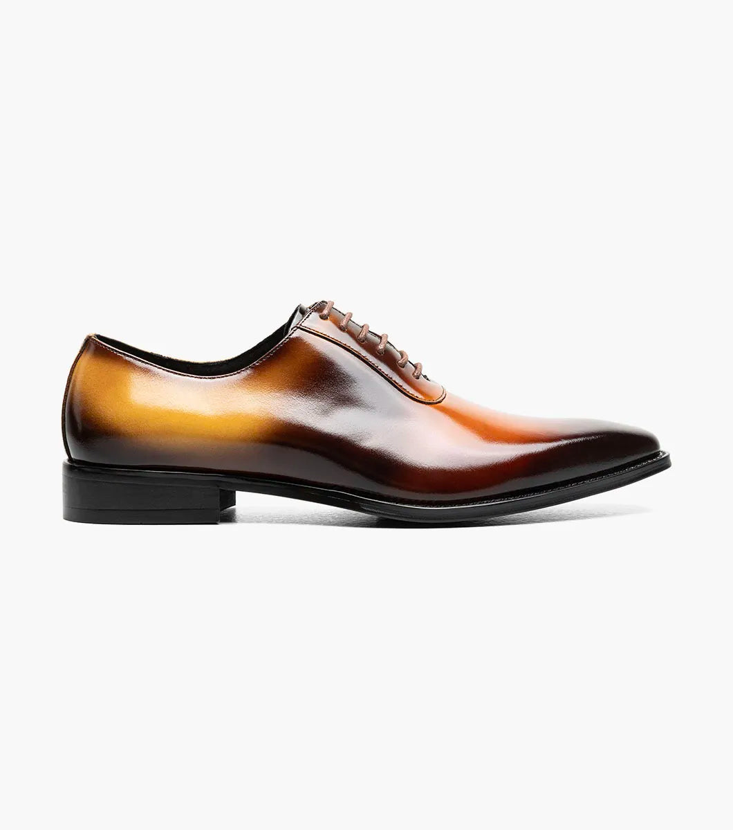 The STACY ADAMS Shaffer Plain Toe Oxford in Cognac Multi (25763-229) features calf leather with a brown-yellow gradient, laces, a low heel, memory foam insole, and polished finish, displayed on a white background.