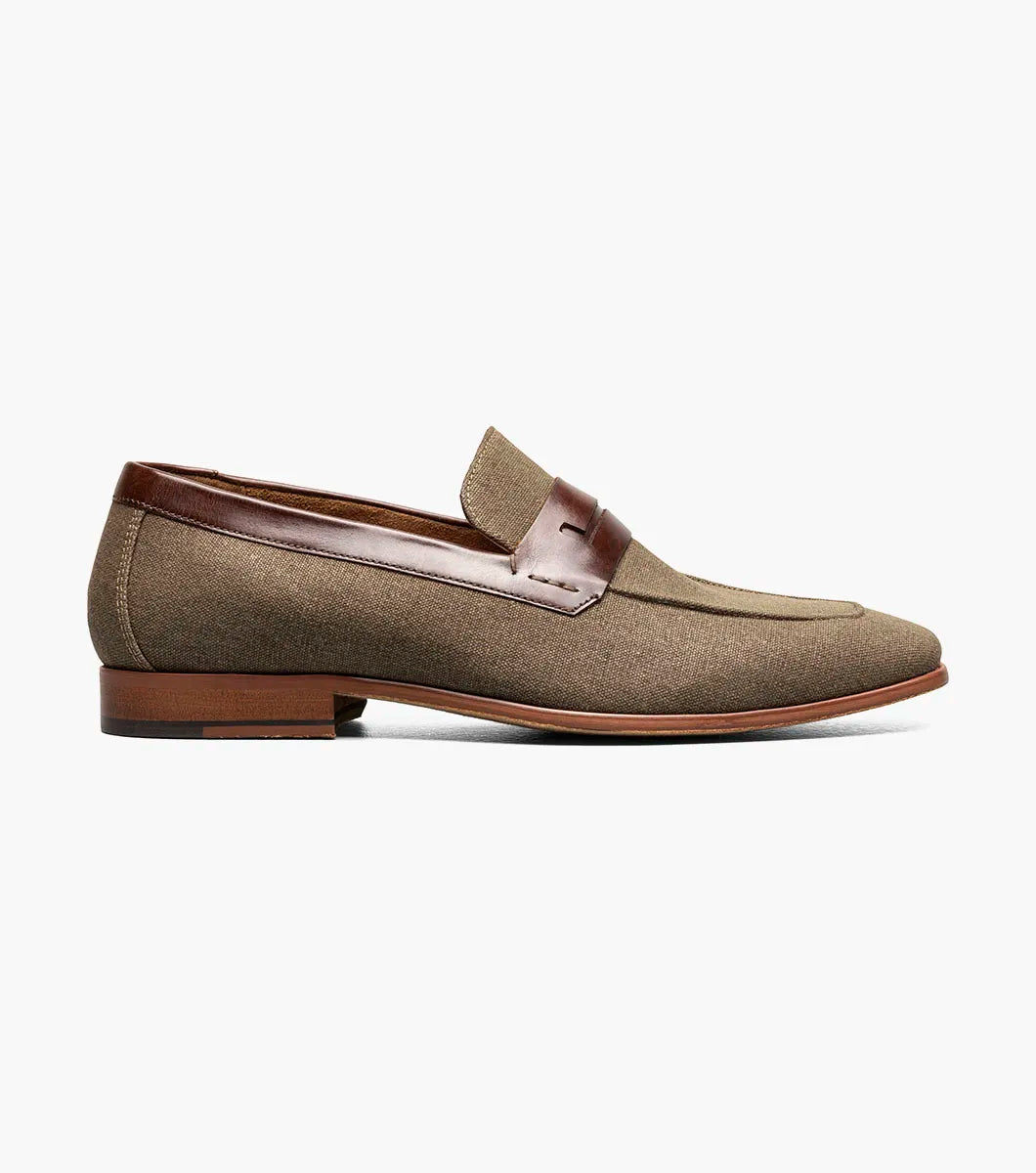 The Stacy Adams Gill Moc Toe Saddle Slip On in Mushroom Multi features a brown fabric upper, smooth leather strap and trim, low wooden heel, and moc toe design by STACY ADAMS. Product code: 25651-053. Displayed on a plain white background.