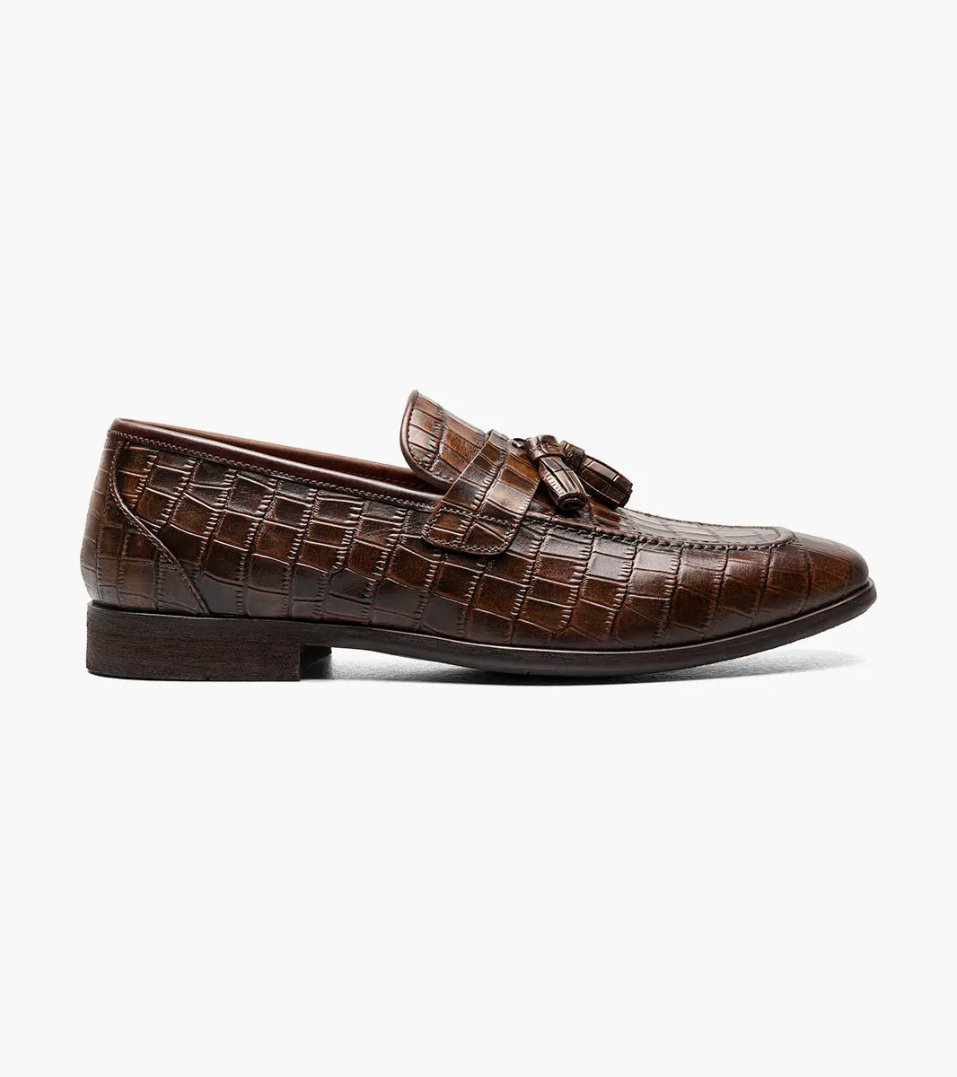 The Stacy Adams Franz Moc Toe Tassel Slip On in Cognac features crocodile print leather, cushioned footbed, low heel, and rounded toe. Product: 25624-221 by STACY ADAMS, shown on a white background.