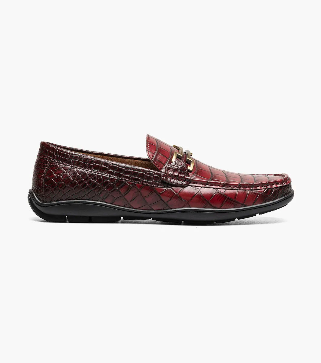 The STACY ADAMS Embrey Moc Toe Bit Slip On in Wine (25703-609) features a single red crocodile print loafer with a metal bit detail on the man-made upper, shown against a white background.