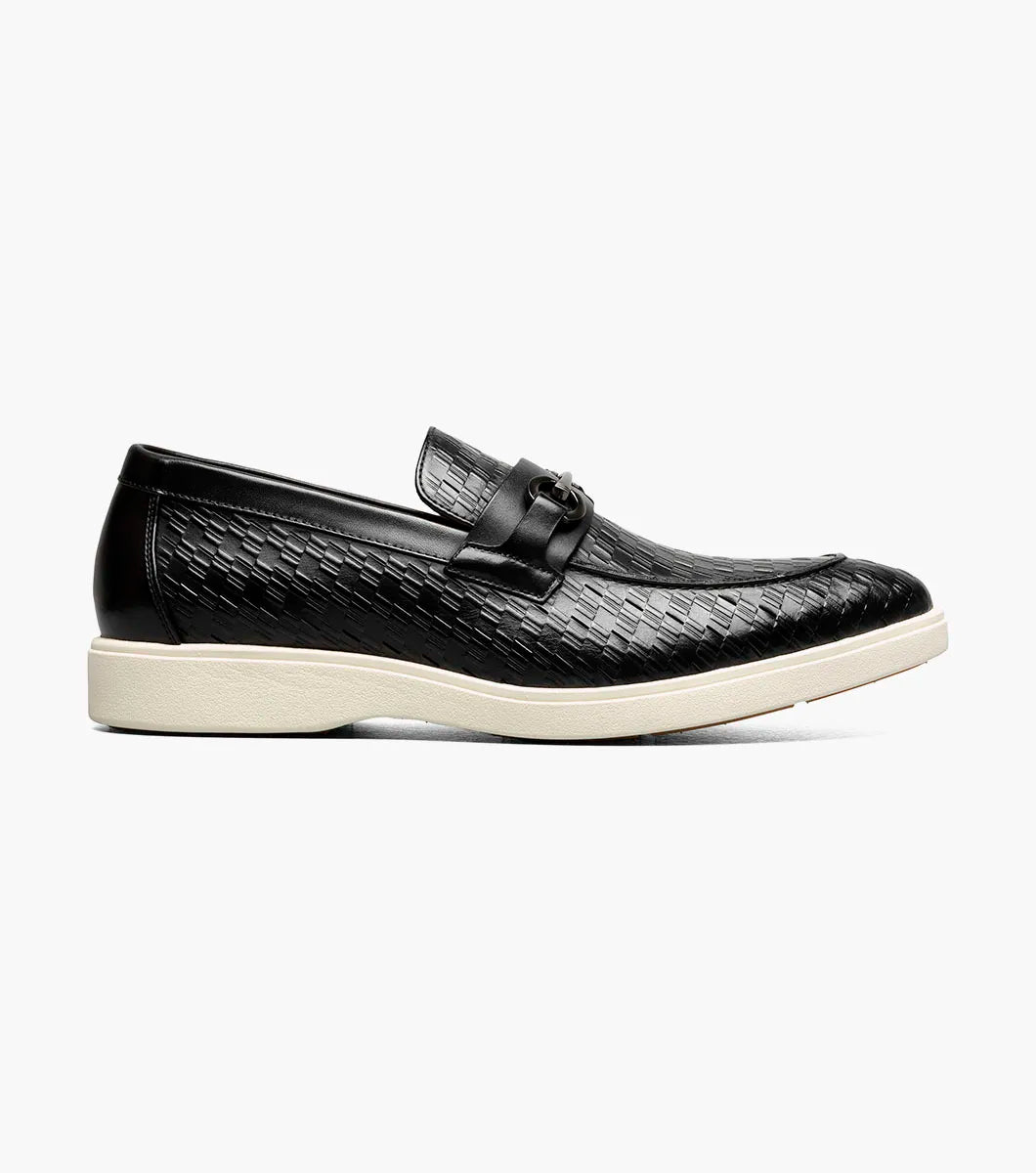 The STACY ADAMS Salyer Moc Toe Bit Slip On (25692-001) features black textured leather, a metal bit detail, and a white sole—perfect for dress occasions, shown on a plain white background.