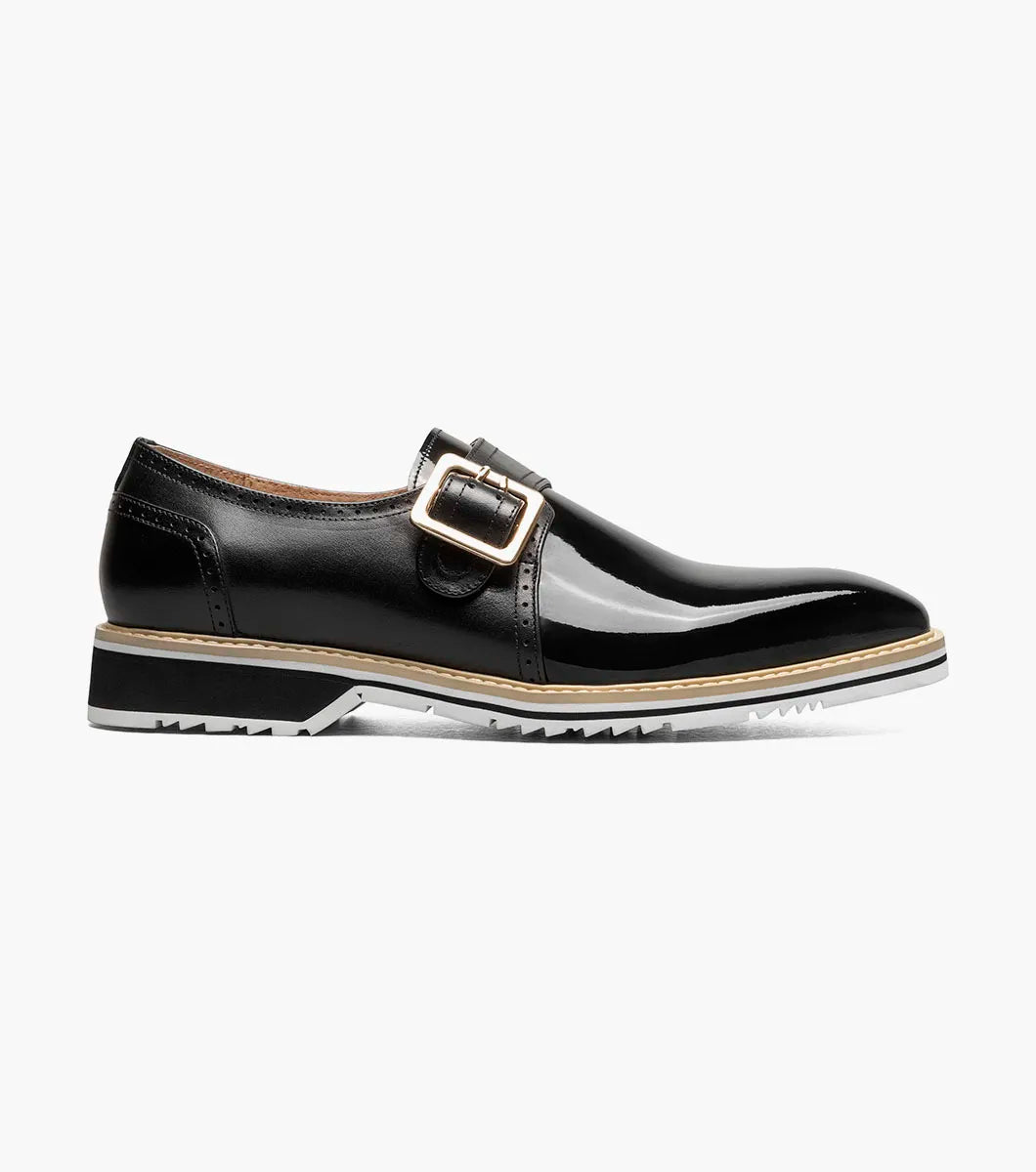 The STACY ADAMS Bartram Plain Toe Monk Strap (25724-001) is a black patent leather dress shoe with a silver buckle, low heel, leather upper, and a two-tone black and white sole.
