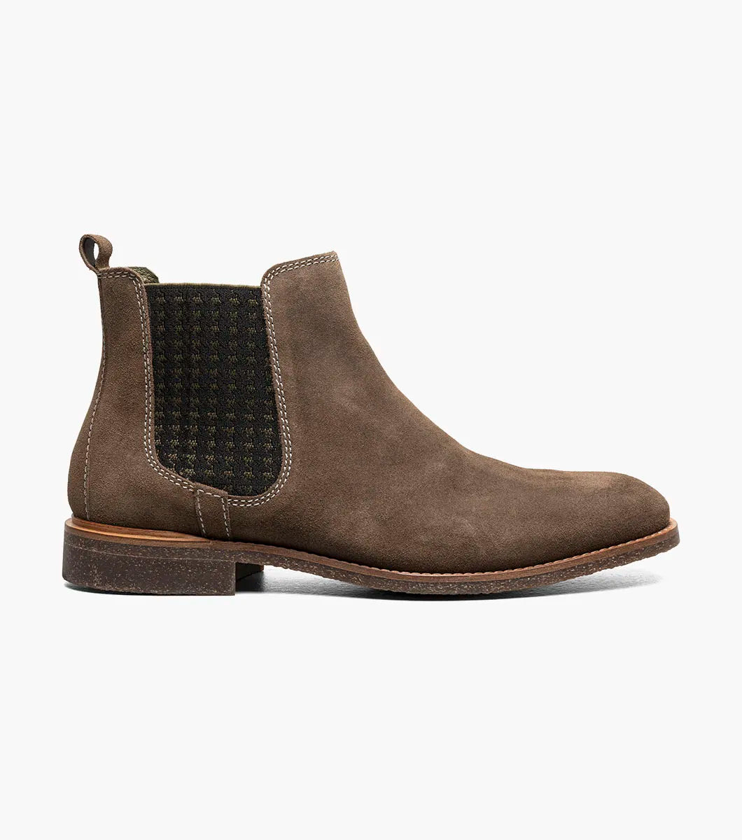 The STACY ADAMS Gabriel Plain Toe Chelsea Boot in Mushroom (25625-051) features a brown suede upper, side elastic panel, back pull tab, low heel, and cushioned RedZone footbed, displayed on a plain white background.