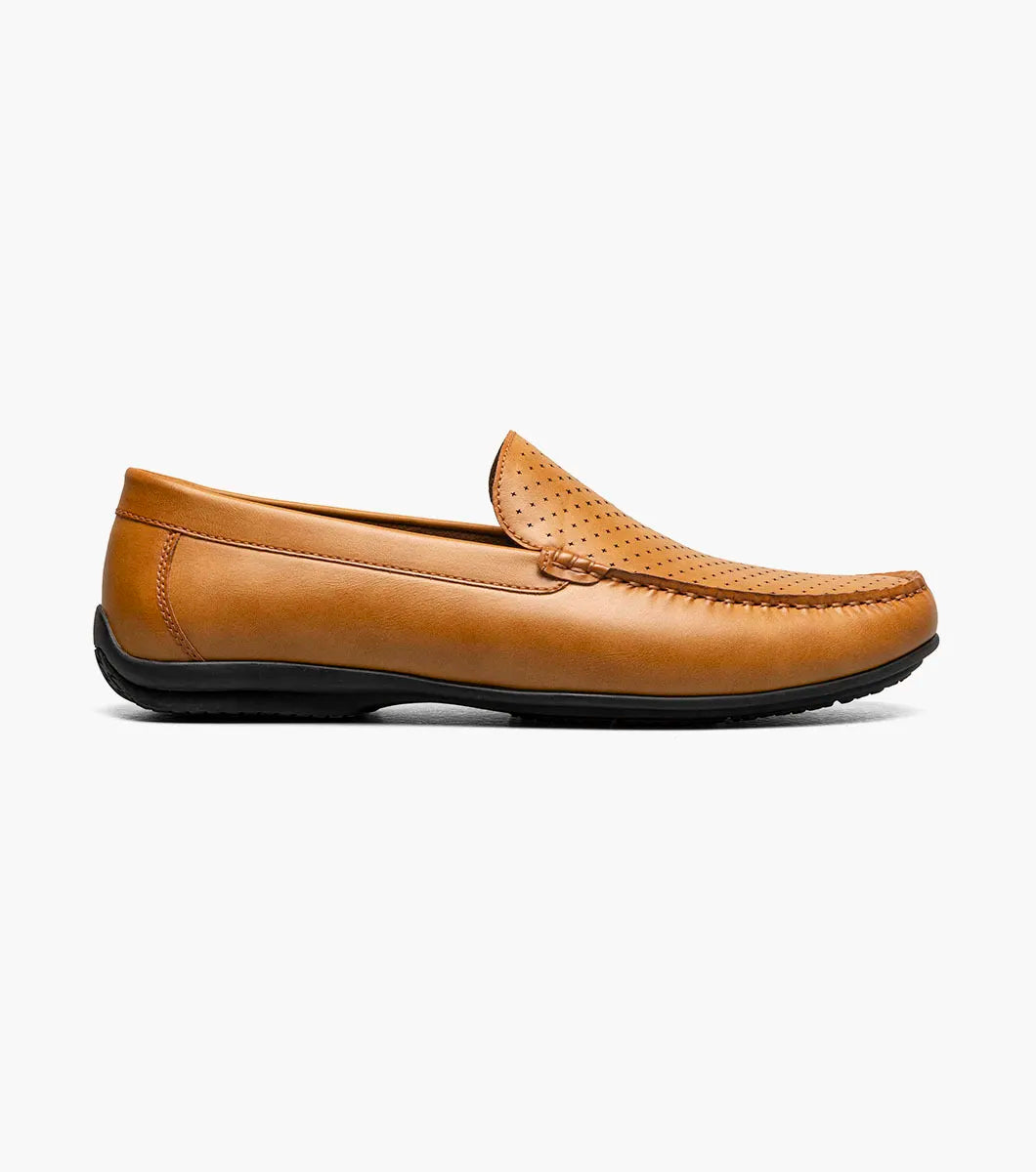 The STACY ADAMS Conroy Moc Toe Perf Slip On (25702-240) in tan features perforated leather uppers, cushioned footbed for all-day comfort, and is shown in a side profile against a white background.