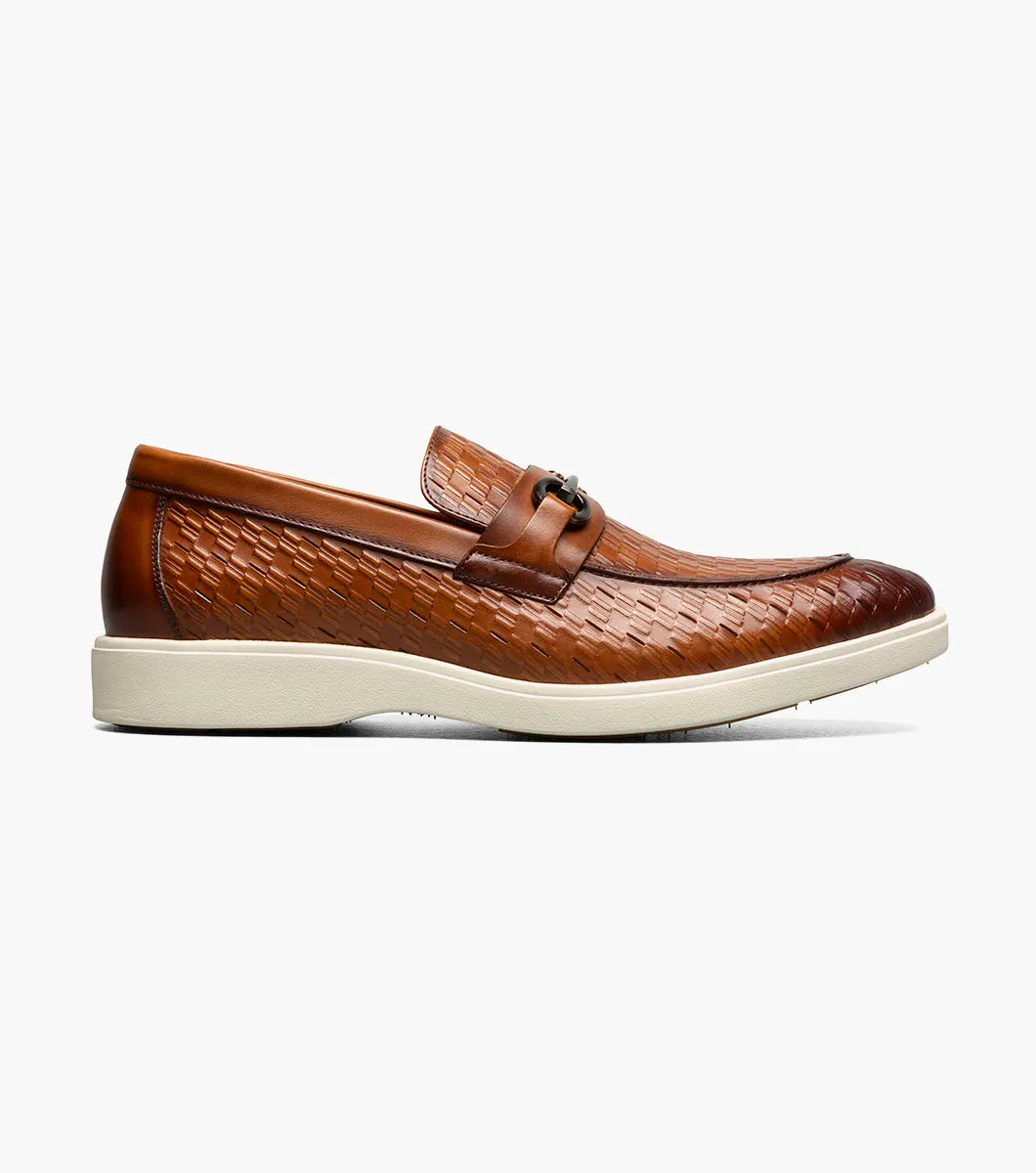 The Stacy Adams Salyer Moc Toe Bit Slip On in tan features printed leather, a silver bit detail, anatomical arch support, and a white rubber sole by STACY ADAMS, shown on a plain white background.