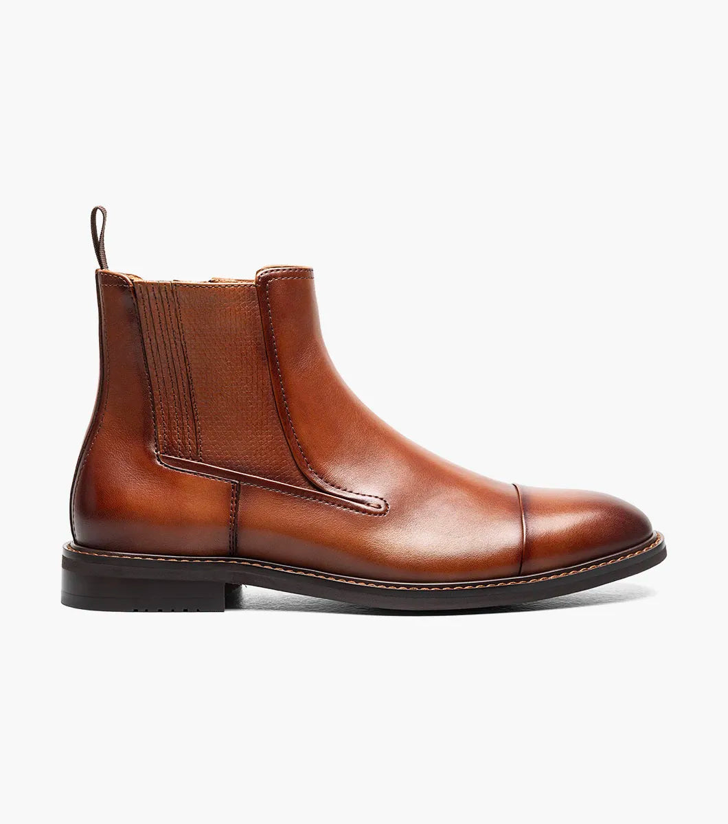 The Stacy Adams Berkshire Cap Toe Side Zip Boot in Brandy features a burnished brown leather upper, rounded cap toe, low heel, stitched detailing on the sole and toe, and is finished with an elastic side panel and back pull tab.