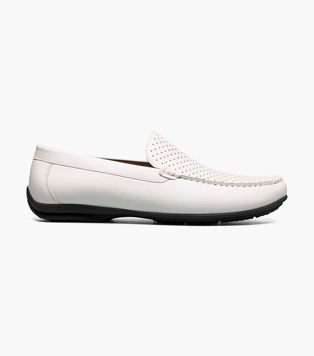 The Stacy Adams Conroy Moc Toe Perf Slip On in white features a perforated leather upper, visible stitching, black rubber sole, and cushioned footbed for comfort. Shown in side profile on a plain background.
