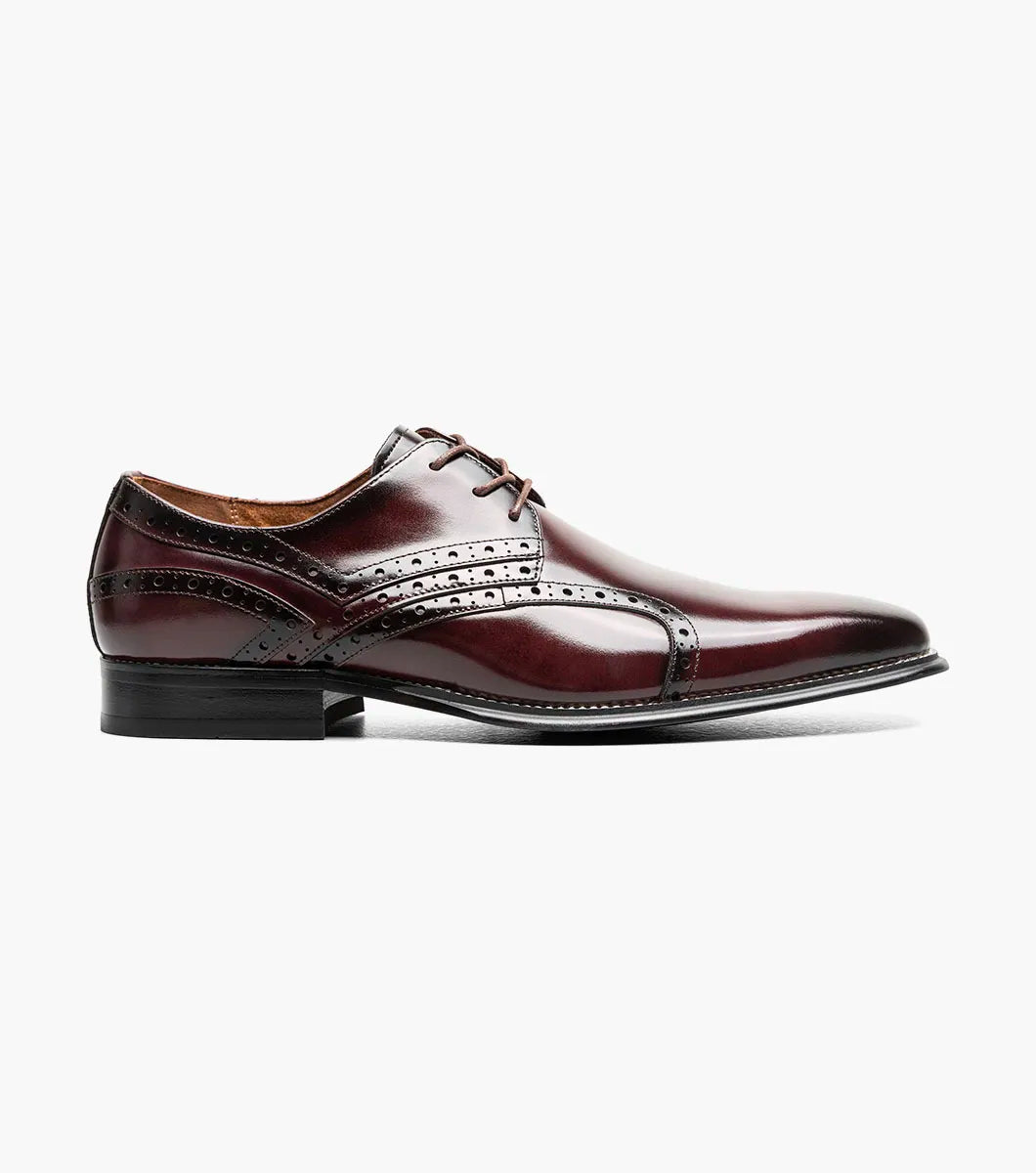 The Stacy Adams Alexander Plain Toe Oxford in Burgundy (style 25791-601) is a men’s dress shoe crafted from glossy oxblood calf leather, featuring brogue detailing, a lace-up closure, and a low black heel, displayed against a plain white background.