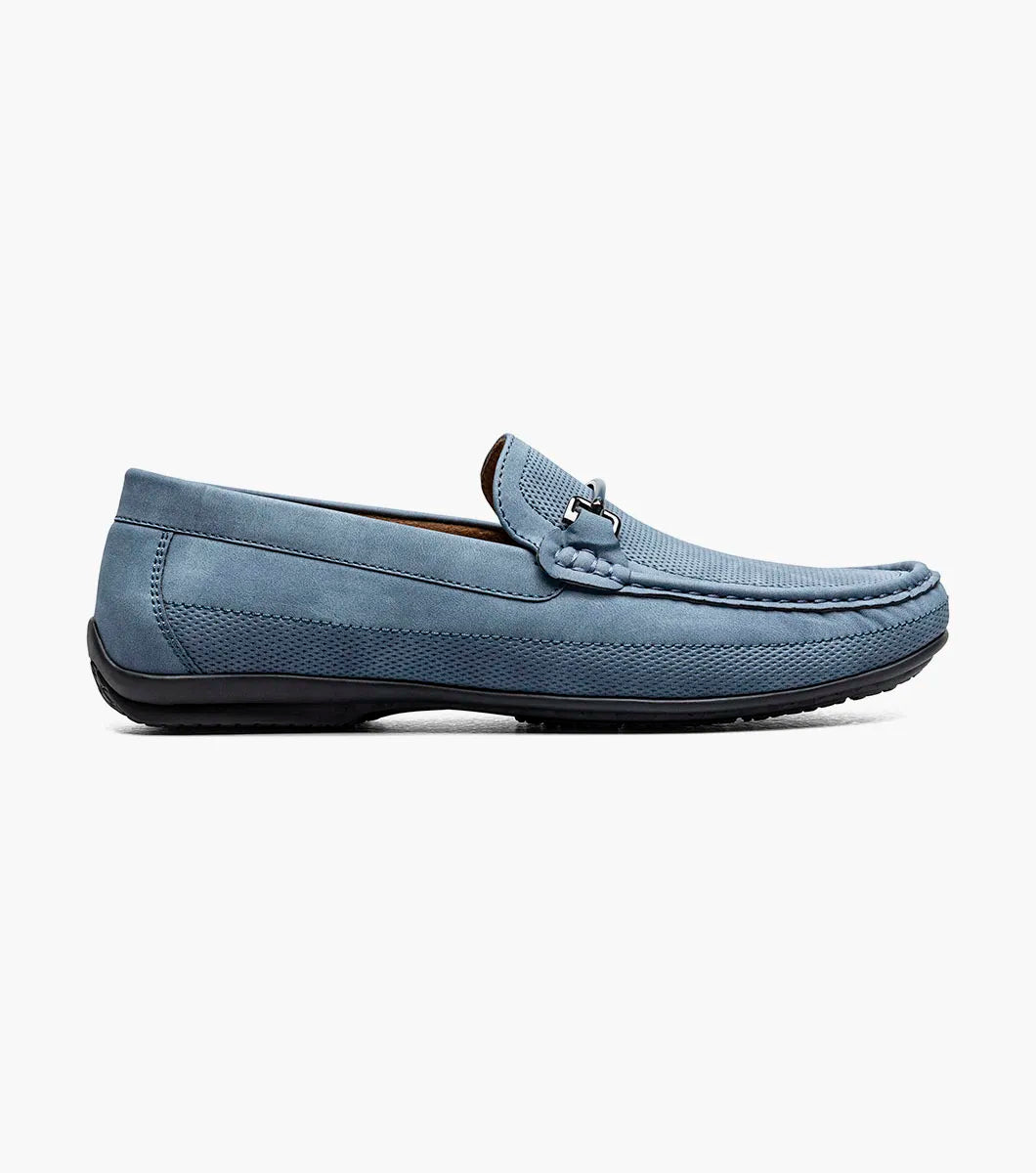The STACY ADAMS Colton Moc Toe Bit Slip On (Navy, 25760-410) features a cushioned footbed, metal bit detail, moc toe stitching, and a flat black sole, shown on a white background.