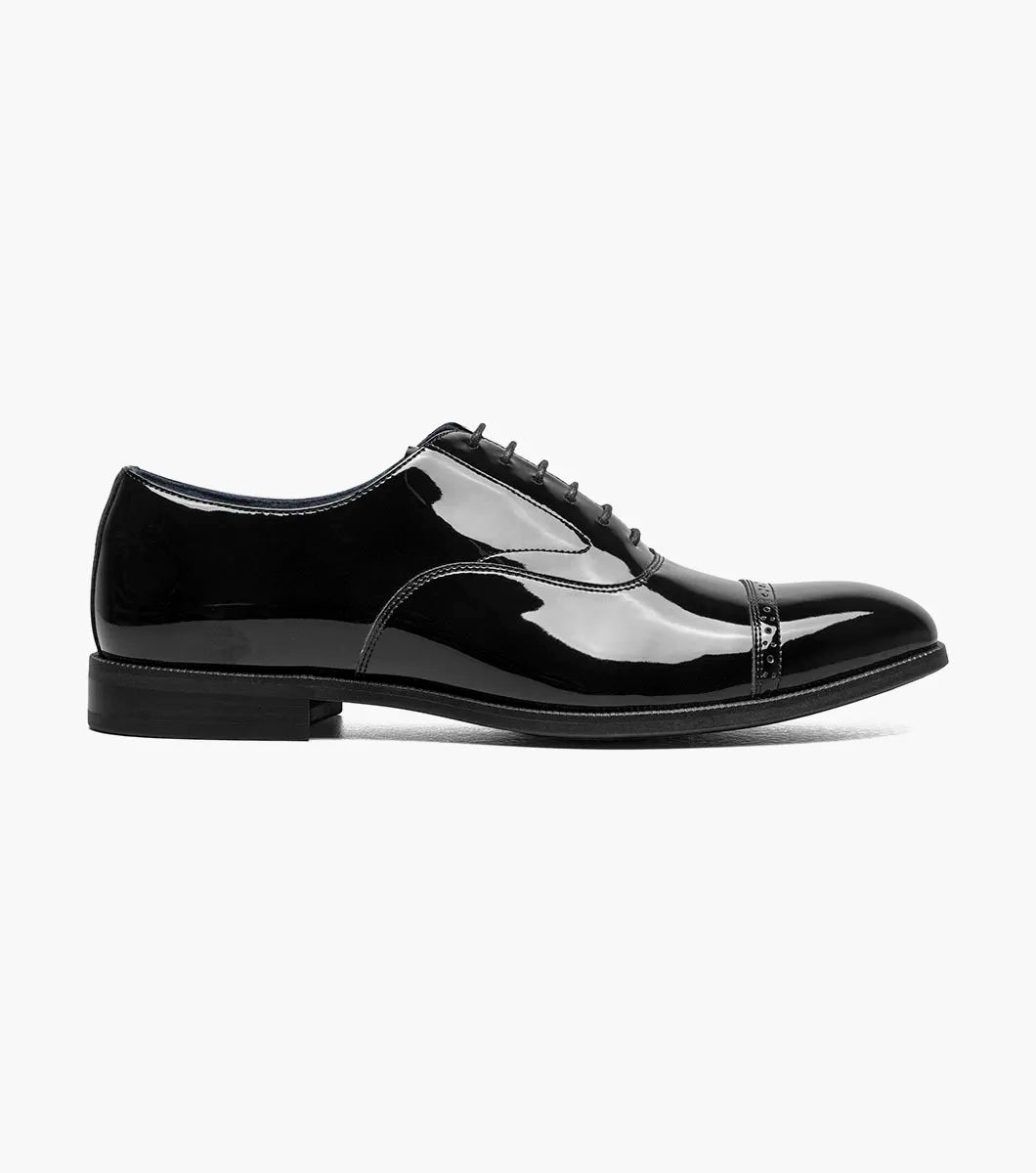 The Stacy Adams Concorde II Cap Toe Oxford (25721-004) is a black patent leather dress shoe with decorative stitching, black laces, and Goodyear Welt Construction, shown in side profile on a white background.