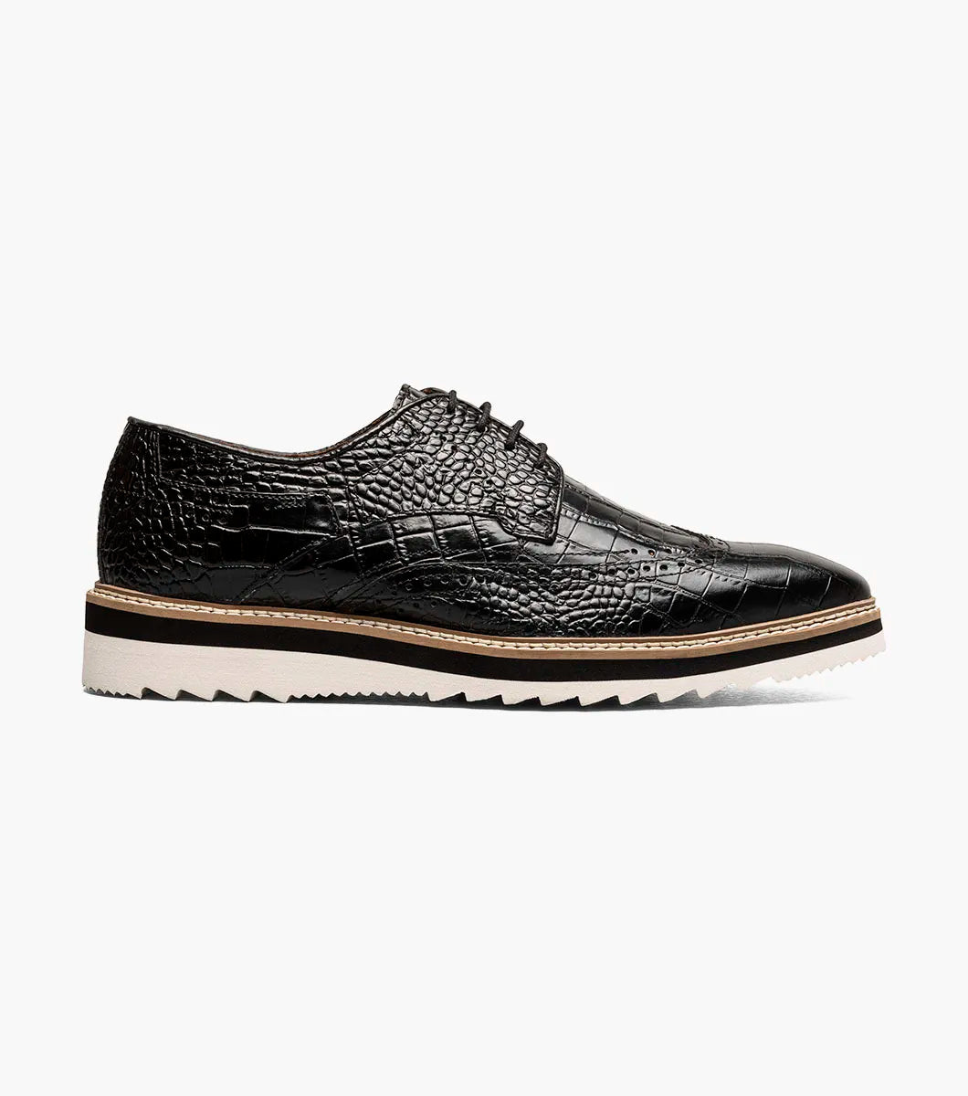 A black Stacy Adams Alario Wingtip Oxford (25725-001) is shown on a plain white background, featuring a molded heel cup, anatomical arch support, and a cushioned footbed for all-day comfort.