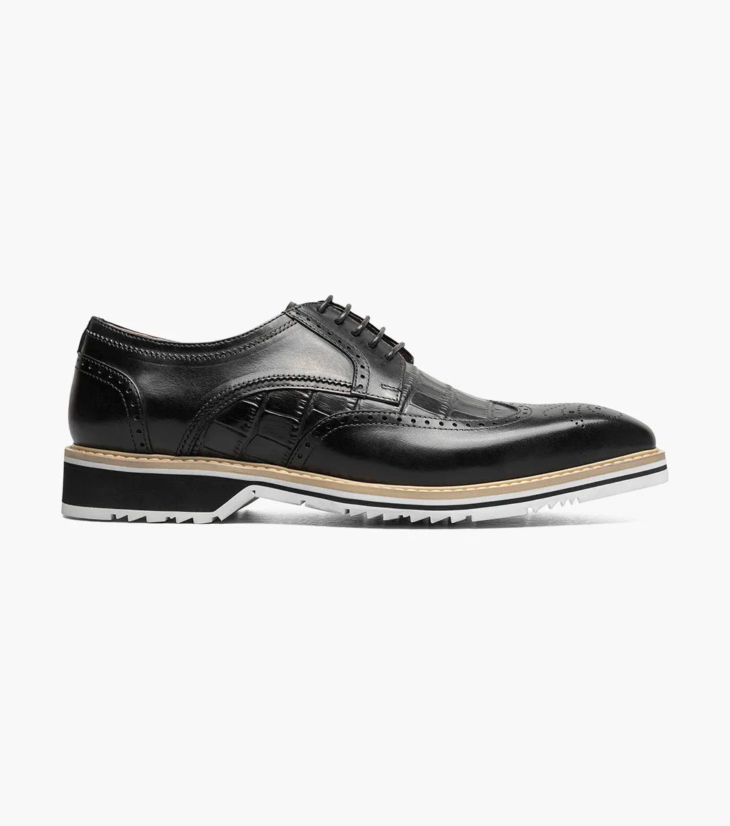 The Stacy Adams Beaumont Wingtip Oxford in black (25723-001) features brogue detailing, lace-up closure, soft leather linings for comfort, and a contrasting white sole by STACY ADAMS, displayed on a plain white background.