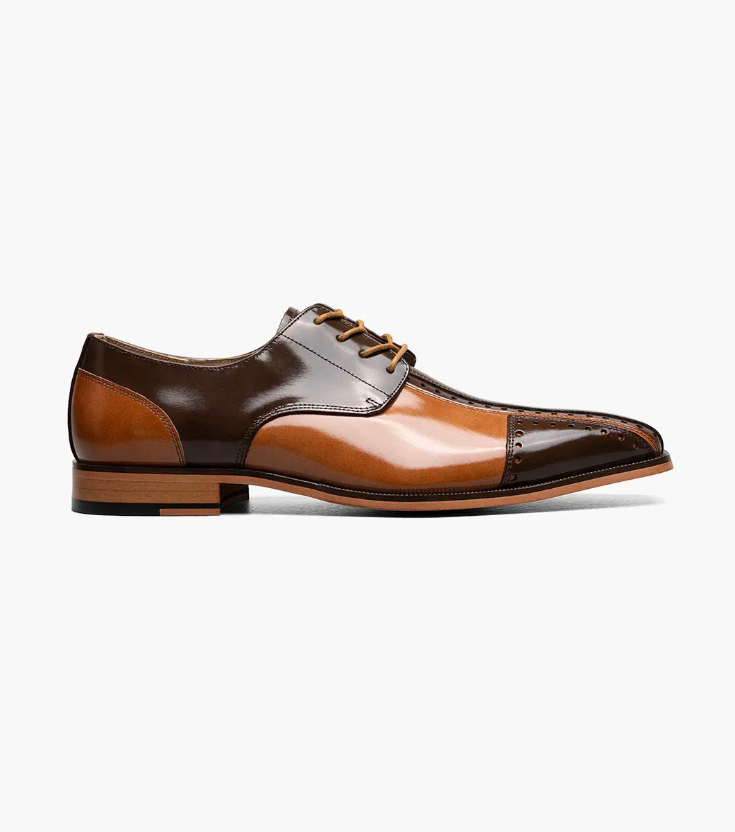 The STACY ADAMS Palmento Modified Cap Toe Oxford (Brown Multi, 25740-249) features a two-tone glossy leather upper, lace-up closure, perforated cap toe detail, and a low wooden heel.