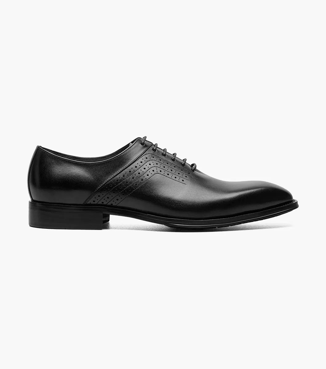 The STACY ADAMS Halloway Plain Toe Oxford in black (25585-001) features a lace-up design and side perforations. This stylish leather dress shoe offers timeless sophistication, shown against a plain white background.