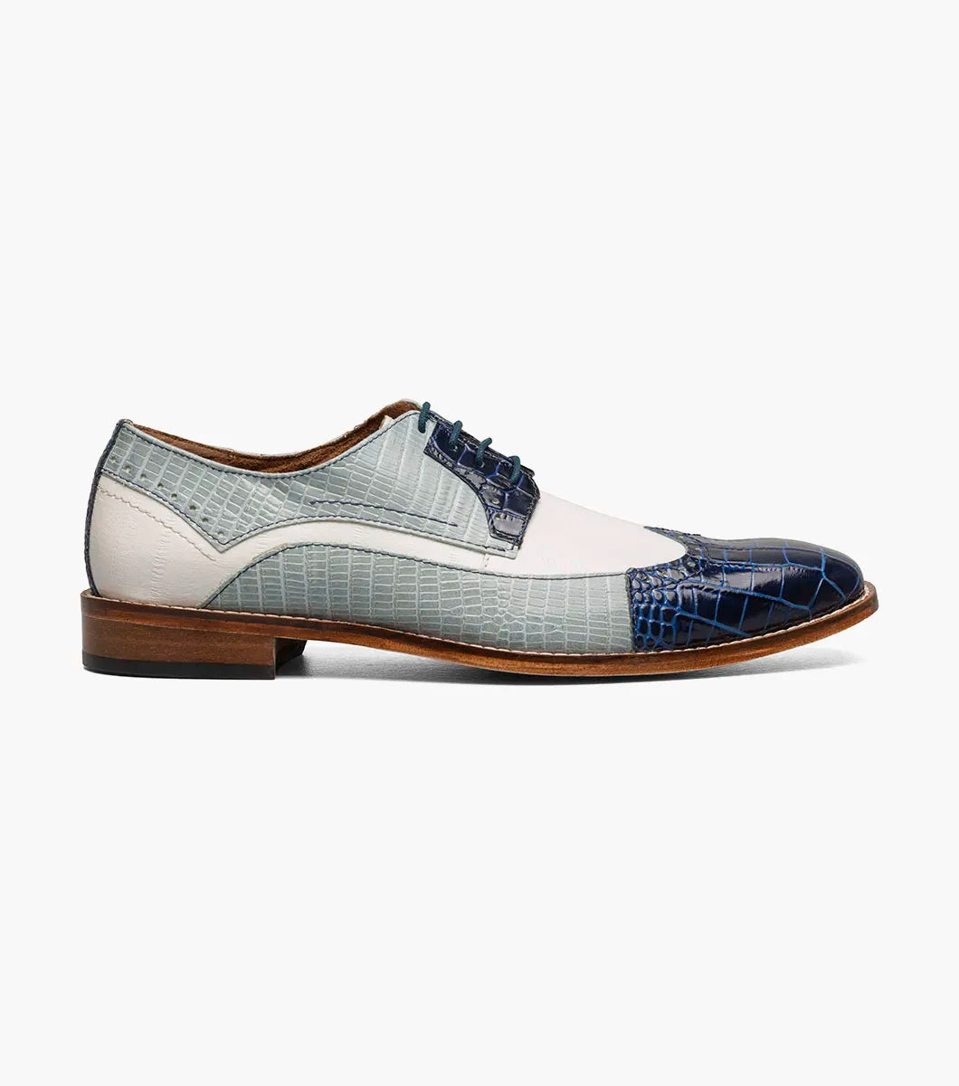 The Stacy Adams Gallinari Wingtip Lace Up in Dark Blue Multi features crocodile-patterned blue, gray, and white leather, brown sole and laces, plus a cushioned footbed for comfort.