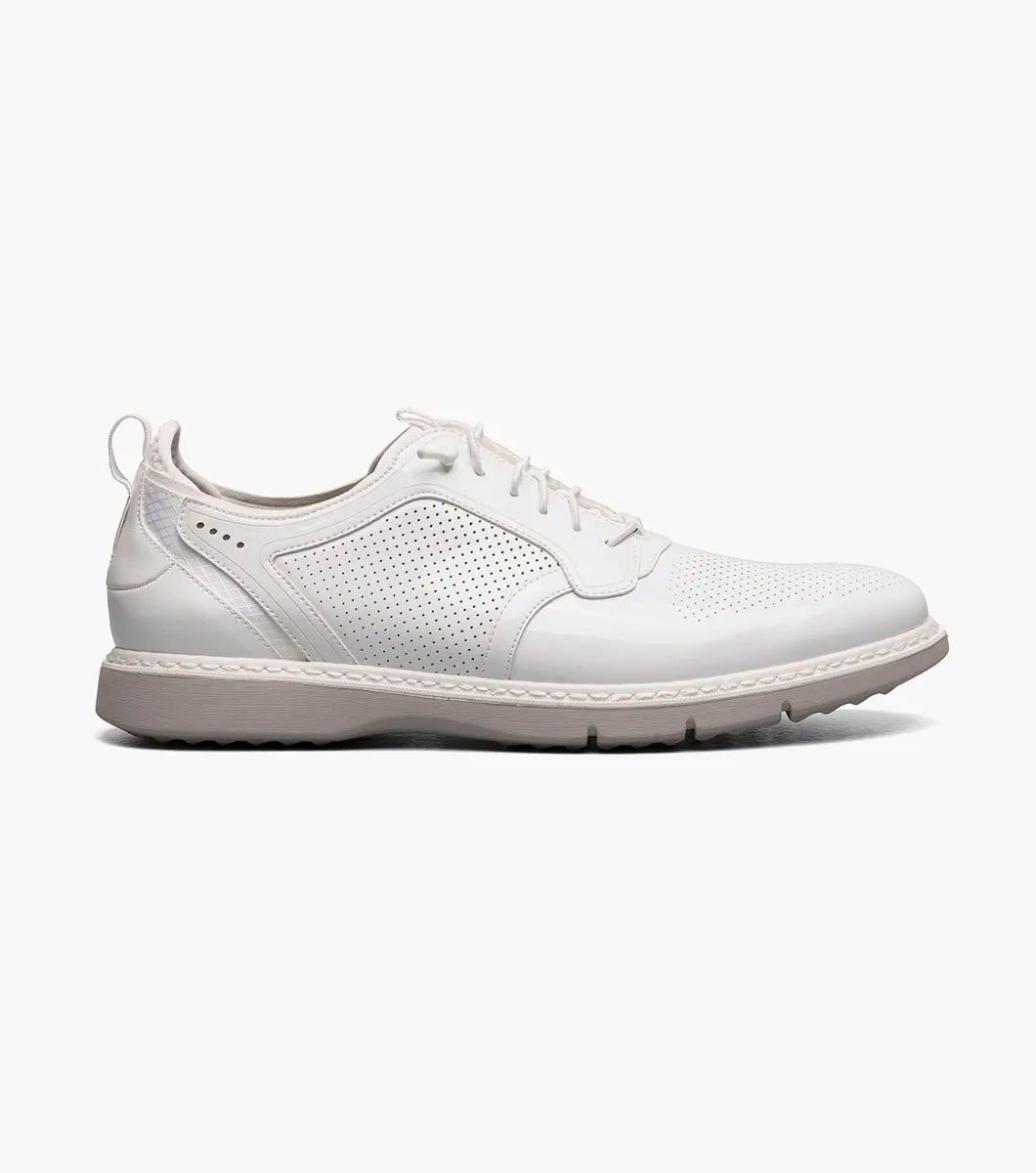 The Stacy Adams Spyre Plain Toe Elastic Lace Up in white patent features perforated detailing, a low heel, and back pull tab—ideal for those seeking stylish and comfortable men’s shoes.