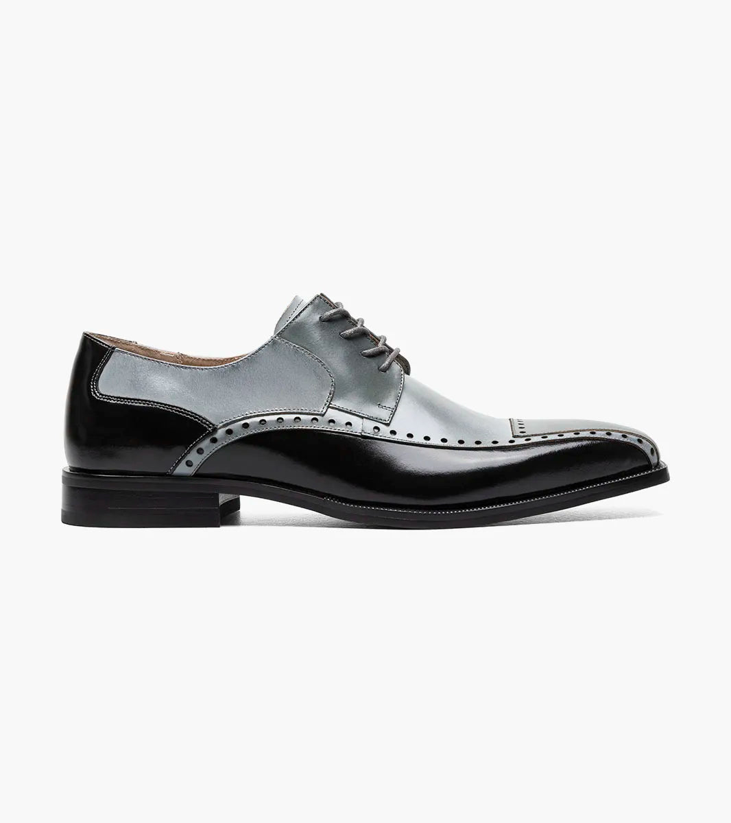 The STACY ADAMS Plaza Modified Cap Toe Oxford in Black/Gray (25608-975) features laces, decorative perforations, and a stylish stacked heel. Shown in profile against a white background.