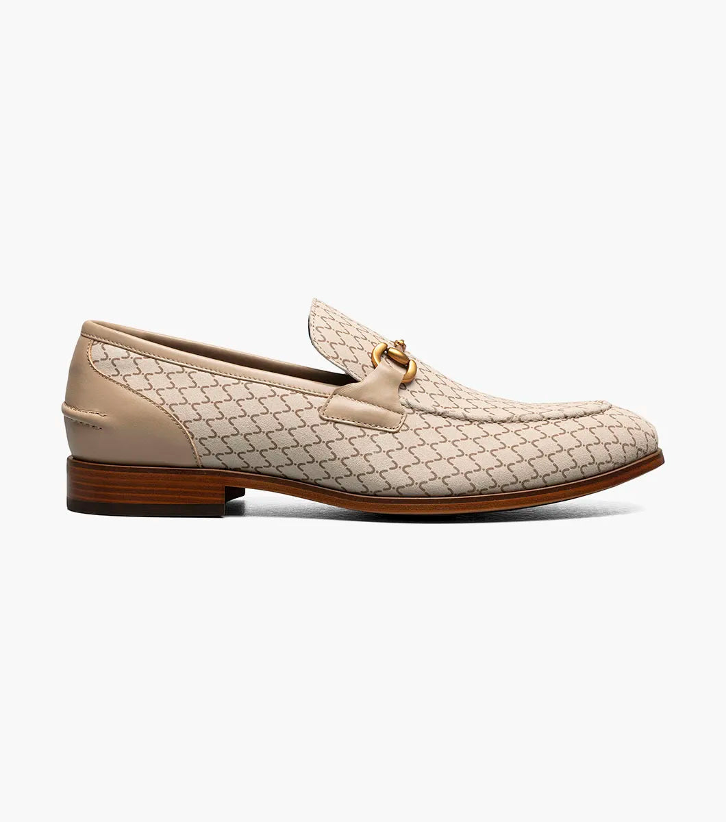 The Stacy Adams Brinkley Moc Toe Bit Slip On in beige features a geometric pattern, leather trim, gold bit detail, wooden heel, and a FlexZone footbed for all-day comfort.