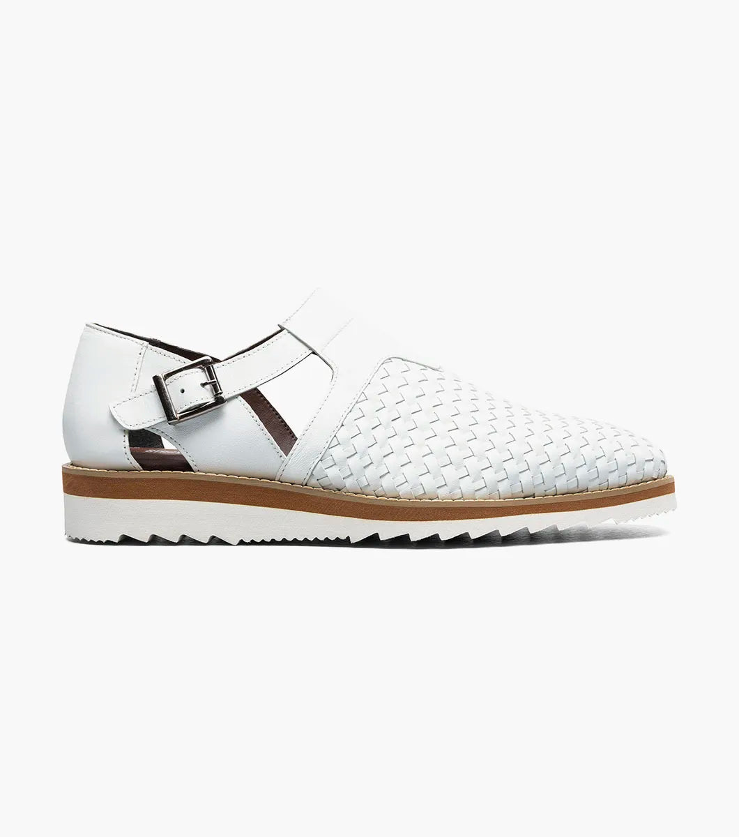 The Stacy Adams Alvarado Woven City Sandal in white features a woven leather upper, buckle strap, brown sole, white serrated outsole, and a soft memory foam insole for comfort. Displayed on a white background.