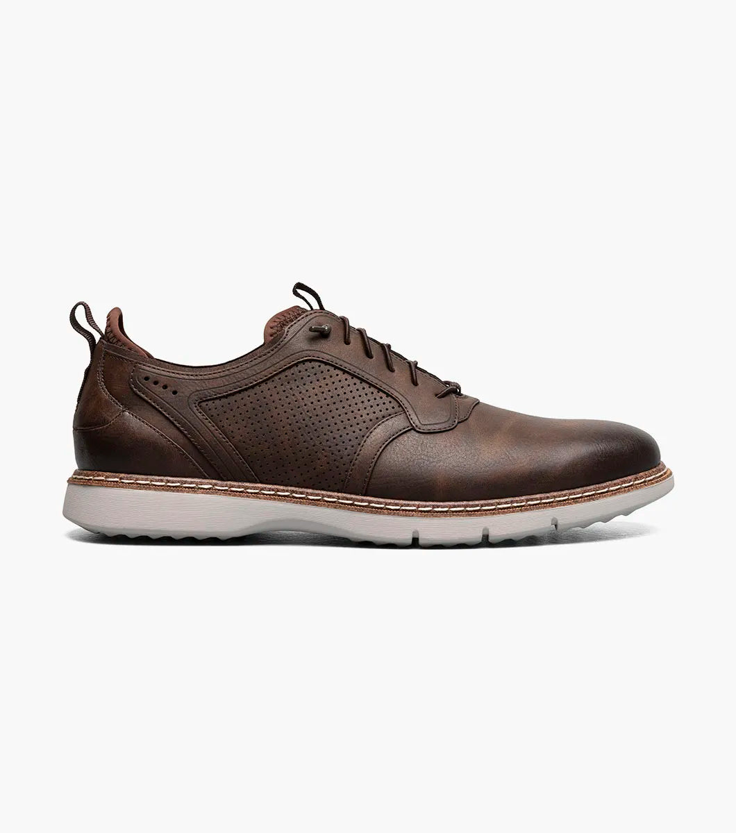 The STACY ADAMS Score Plain Toe Elastic Lace Up in Brown (style 21538-215) is a business-casual leather shoe featuring perforated side panels, a white sole, elastic lace-up front, and detailed stitching with a supportive RedZone footbed—displayed against a plain white background.