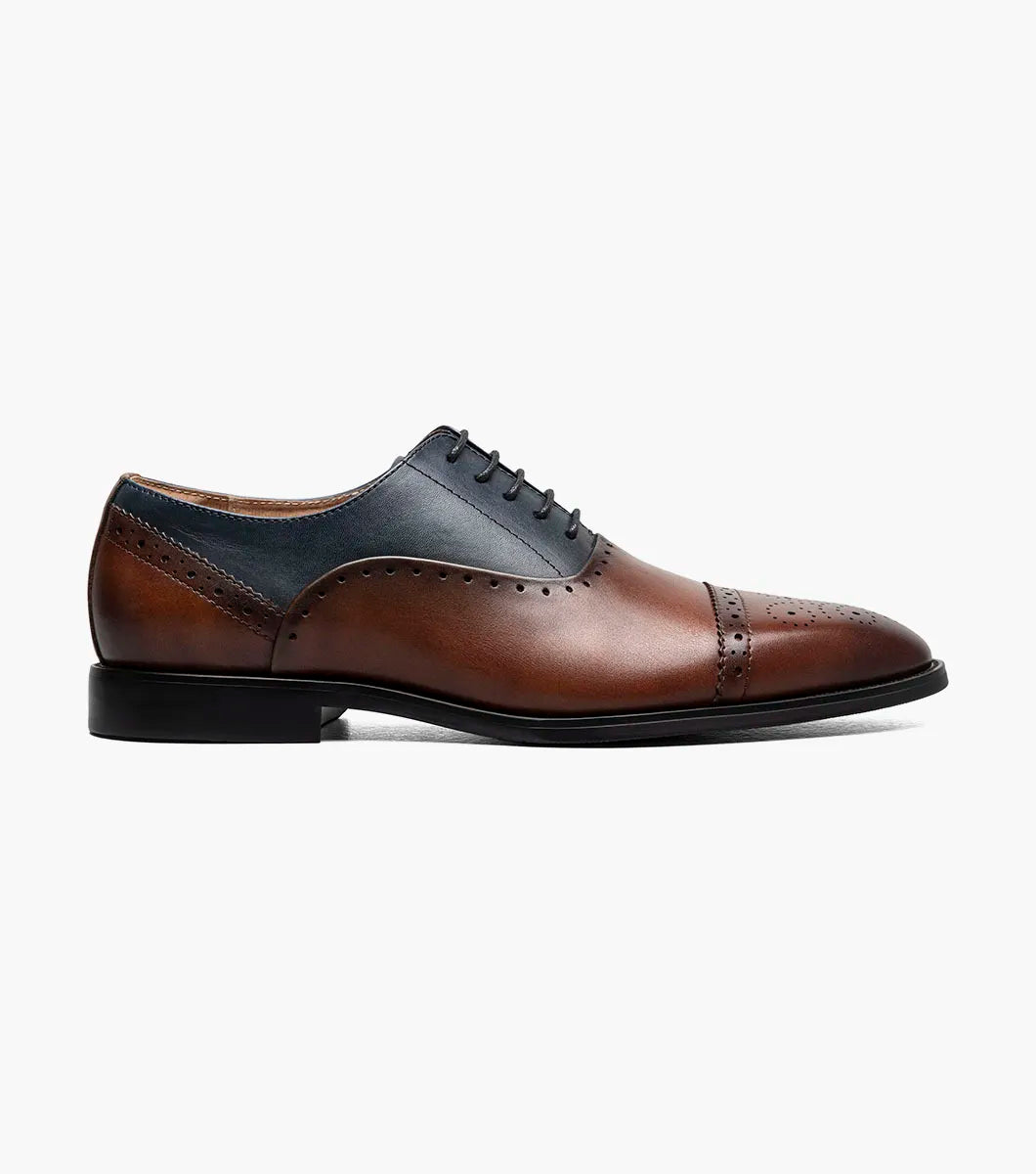 The Stacy Adams Reynolds Cap Toe Oxford (25670-989) features brown and navy leather, perforated detailing, closed lacing, a memory foam insole, and a low black heel.