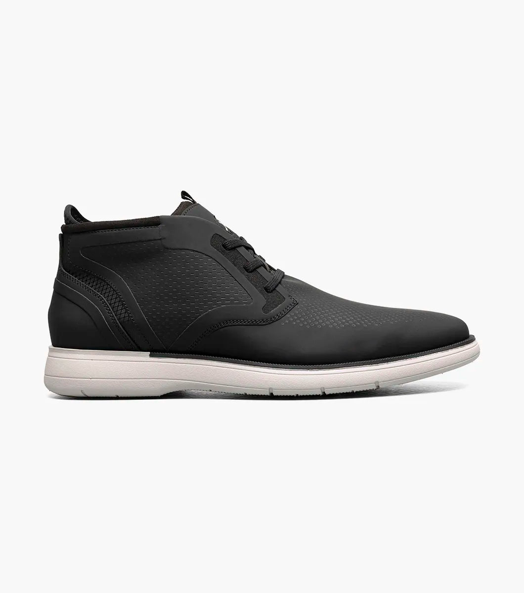 The STACY ADAMS Eastmont Plain Toe Elastic Lace Chukka Boot in black features a mid-top design, textured upper, elastic laces, white sole, and subtle logo on the tongue.