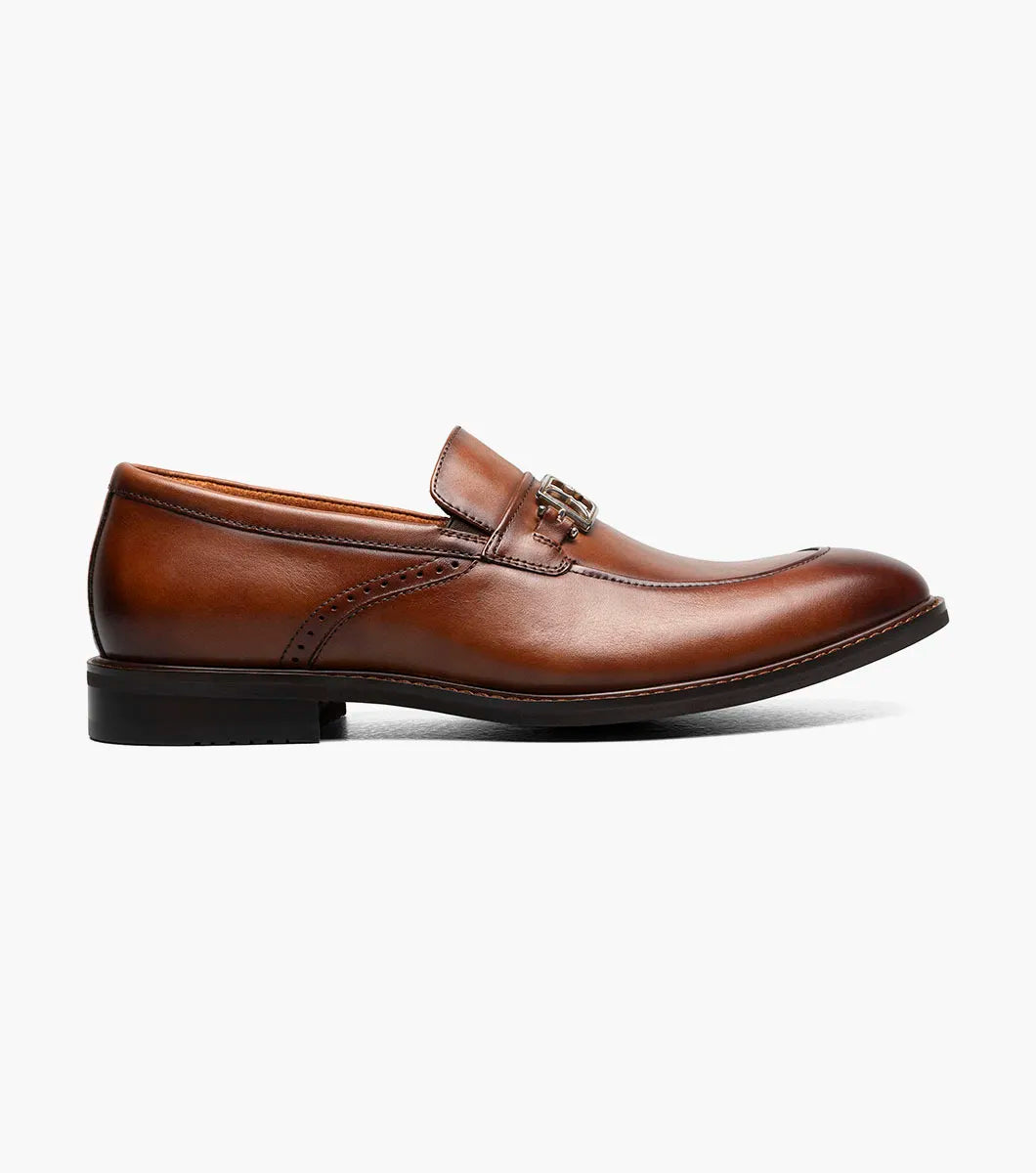The Stacy Adams Boyd Moc Toe Bit Slip On in Brandy features a brown leather upper, moc toe design, metal horsebit detail, low heel, cushioned footbed, and visible stitching. Model 25753-226 by STACY ADAMS shown on a white background.