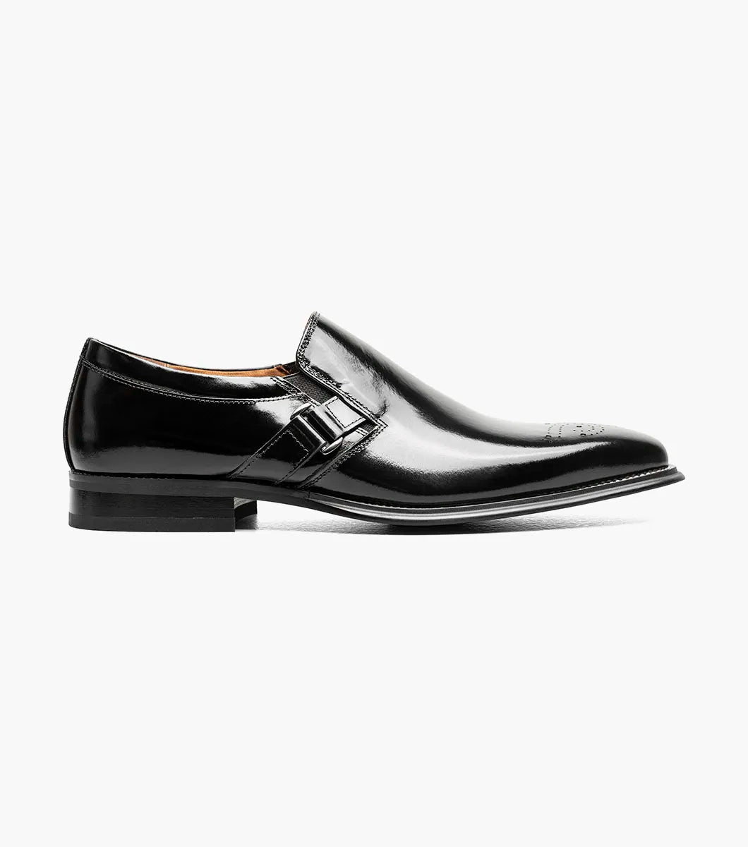 The Stacy Adams Alistair Plain Toe Ornament Slip On in black showcases a sleek leather design with a square toe, decorative stitching on the upper, and an eye-catching side buckle detail. This stylish shoe also features a comfortable memory foam insole and is displayed on a white background.