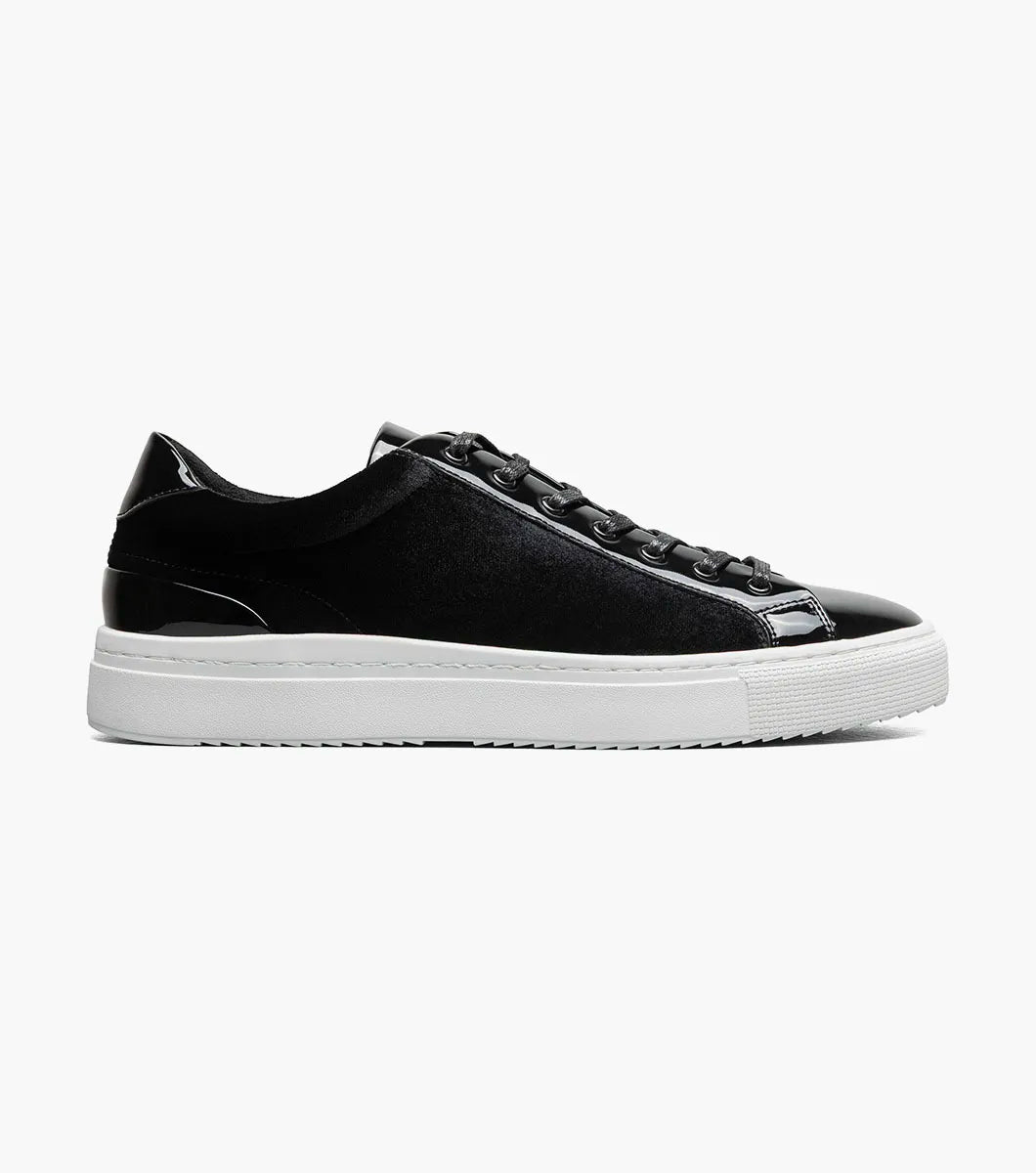 A Stacy Adams Dante Lace To Toe Sneaker in black (style 25806-001) is shown on a white background, featuring shiny patent leather accents, black laces, and a white rubber sole.