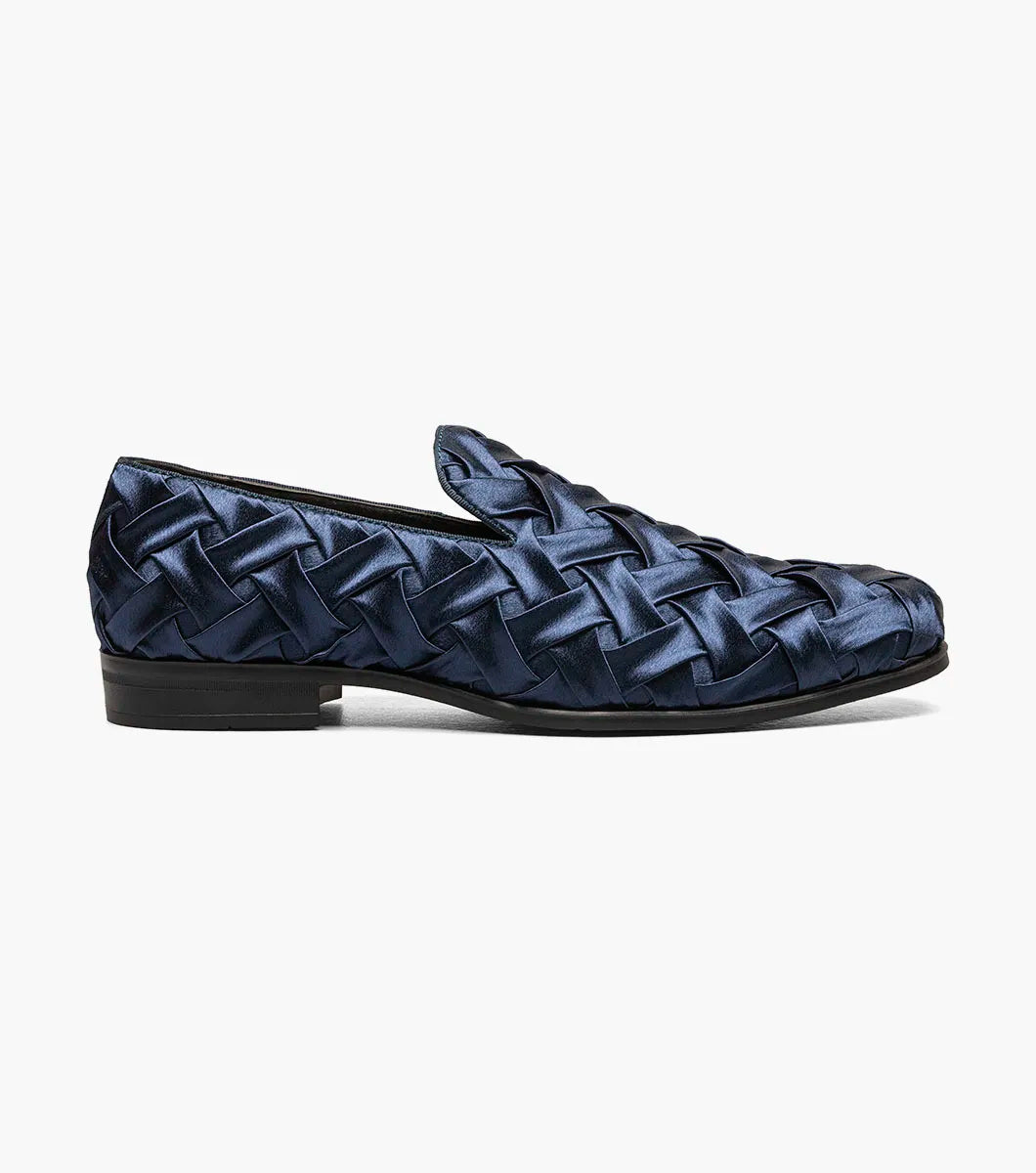 The STACY ADAMS Savoir Plain Toe Satin Slip On (Navy, 25611-410) is a men's loafer with a glossy woven satin design, low black heel, and memory foam insole, shown on a white background.