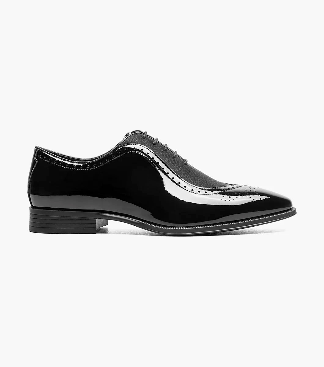 A single STACY ADAMS Stuart Folded Vamp Balmoral Oxford dress shoe in black patent leather (Style 25794-001), featuring laces, a low heel, decorative stitching, and a comfortable Memory Foam insole, is displayed on a plain white background.