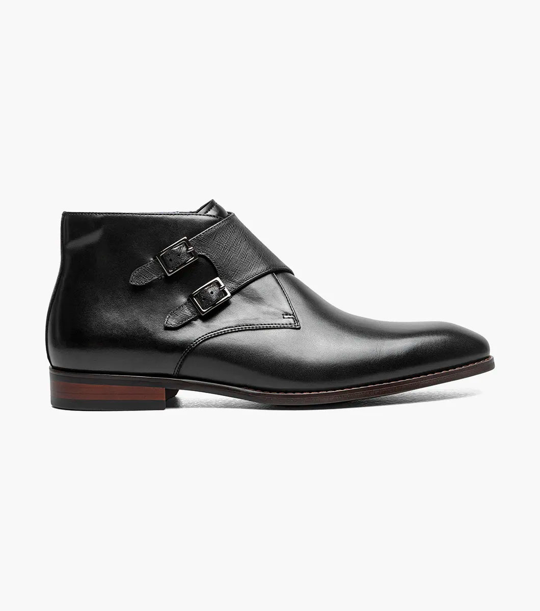 The STACY ADAMS Kaius Plain Toe Double Monk Strap Boot (25733-001) features a black leather upper, silver buckles, low stacked heel, anatomical arch support, and a patterned inner lining.