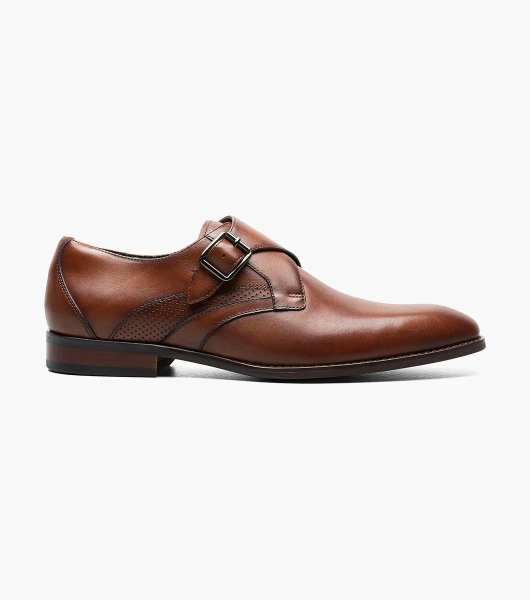 The Stacy Adams Karcher Plain Toe Monk Strap in cognac features a brown leather upper, silver buckle, durable rubber sole, subtle stitching, and low heel. Displayed on a white background. Model: 25590-221. Brand: STACY ADAMS.