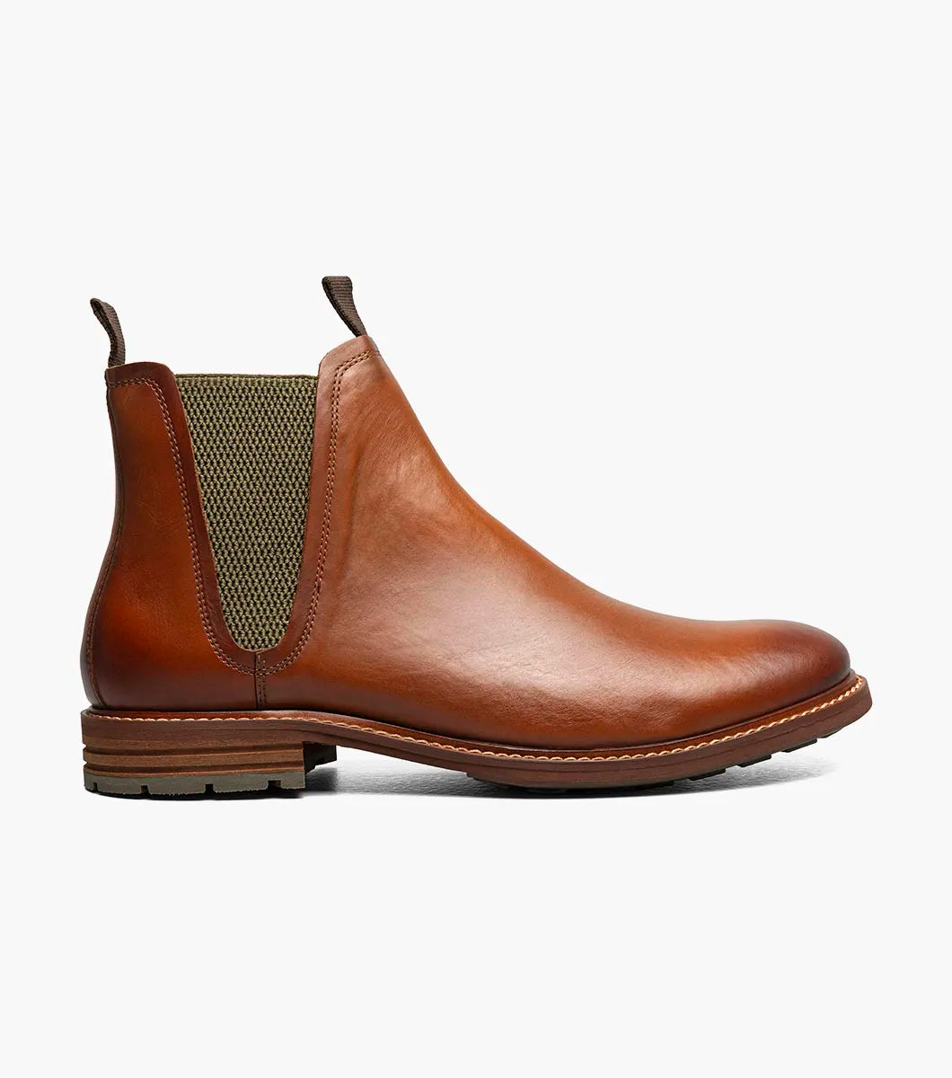 The Stacy Adams Isaacson Plain Toe Chelsea Boot in Cognac features elastic side panels, pull tabs, a low stacked heel, and a supportive leather upper—all displayed on a white background.