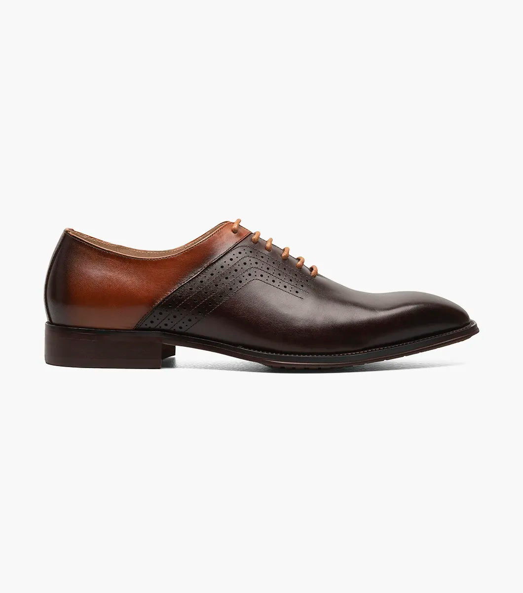 The Stacy Adams Halloway Plain Toe Oxford in Brown Multi features perforated detailing, closed lacing, a low wooden heel, and a cushioned Memory Foam insole. Shown on a plain white background.