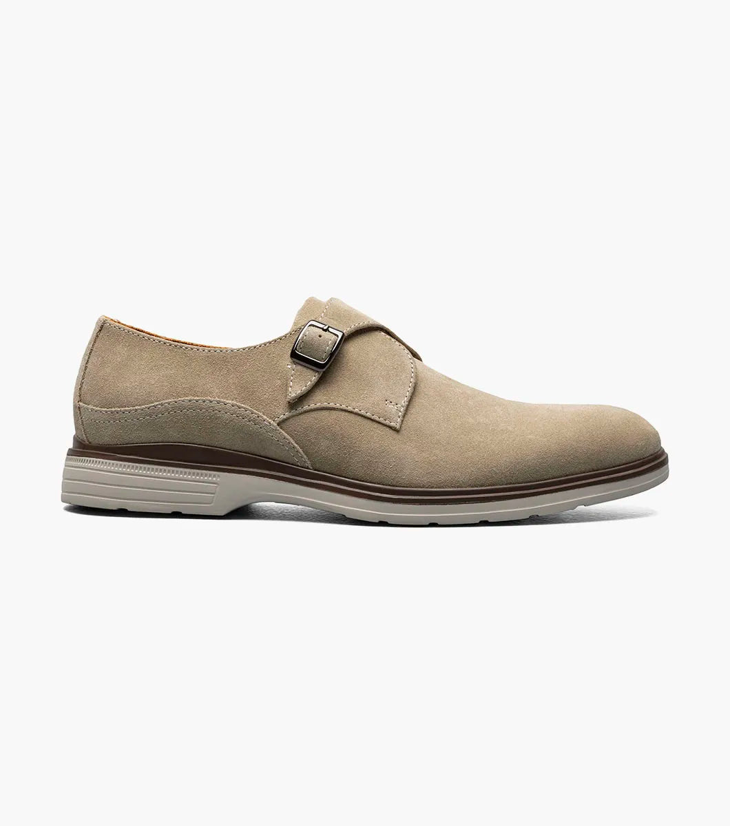 The Stacy Adams Taylen Plain Toe Monk Strap in Sandstone features beige suede leather, a single side buckle, anatomical arch support, low heel, and a textured rubber sole. Displayed on a white background.