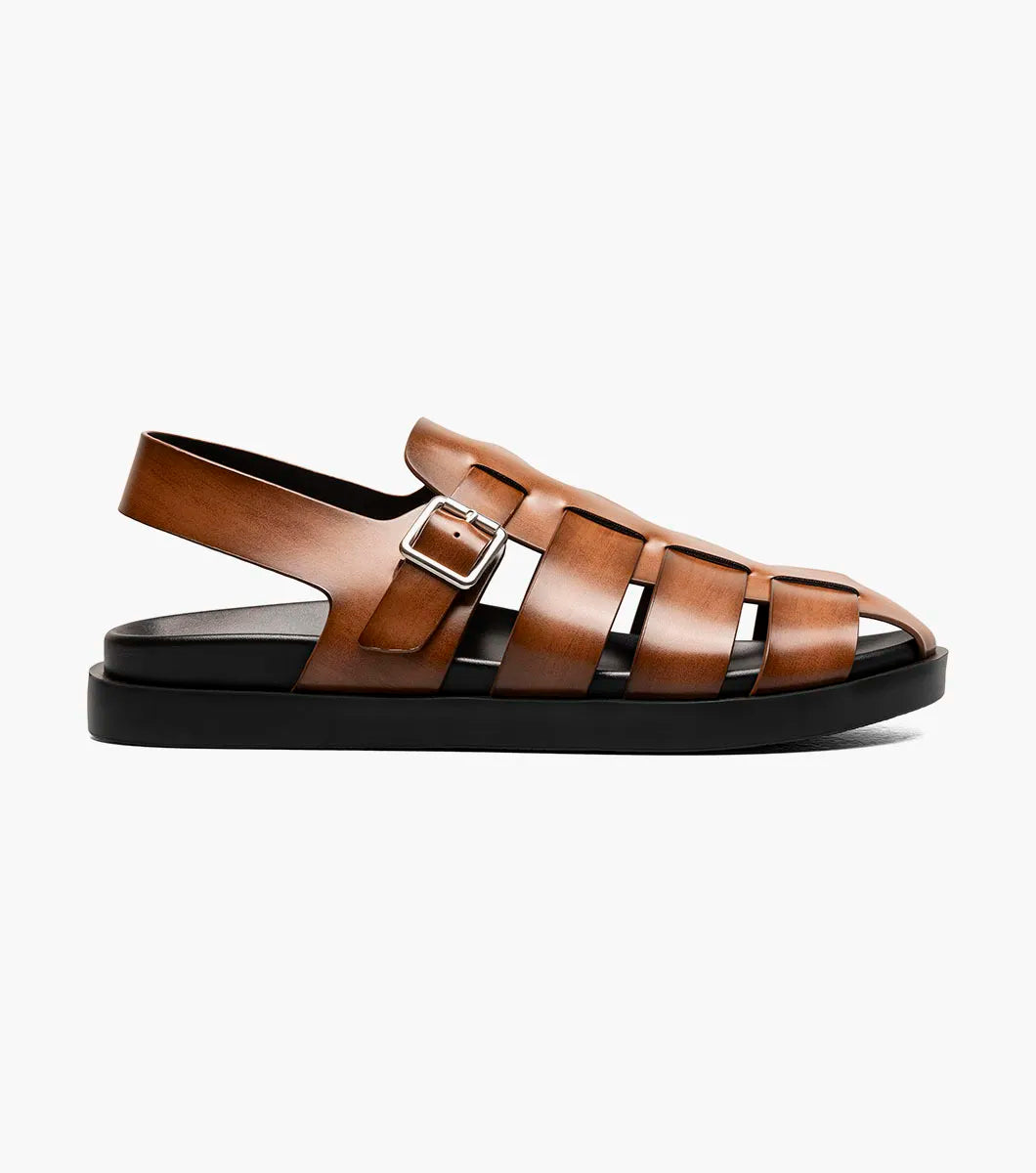 The STACY ADAMS Montego Slingback Buckle Sandal in Cognac (25659-221) features brown leather, a burnished finish, silver buckle, and black sole with EVA midsole, shown in side profile on a plain white background.