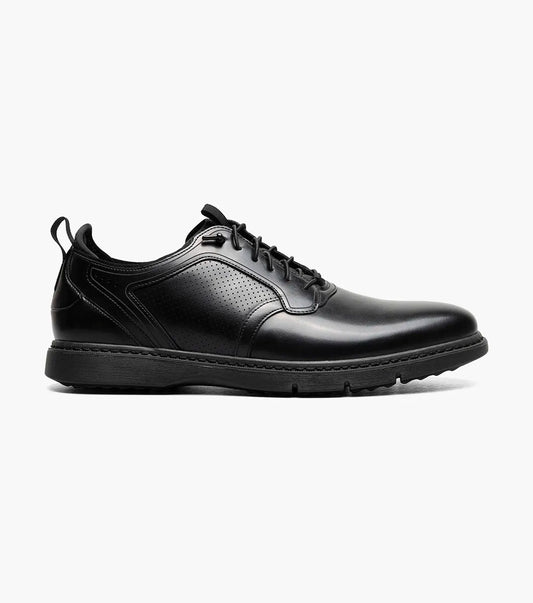 The Stacy Adams Score Plain Toe Elastic Lace Up in Black Smooth (Style 21538-005) is a black leather dress shoe featuring elastic laces, a low heel, a textured sole, and subtle perforated detailing on the side. It includes the RedZone footbed for enhanced comfort and is presented in a side profile against a white background.