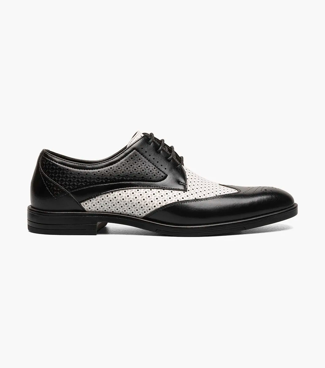 The Stacy Adams Asher Wingtip Lace Up (25653-111) by STACY ADAMS features a black and white leather upper with perforated detailing, lace-up closure, and a low heel, shown on a white background.