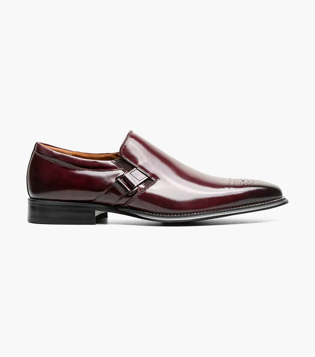 A single STACY ADAMS Alistair Plain Toe Ornament Slip On dress shoe in burgundy, featuring a side buckle detail, perforated toe design, and a comfortable memory foam insole, is displayed on a white background.