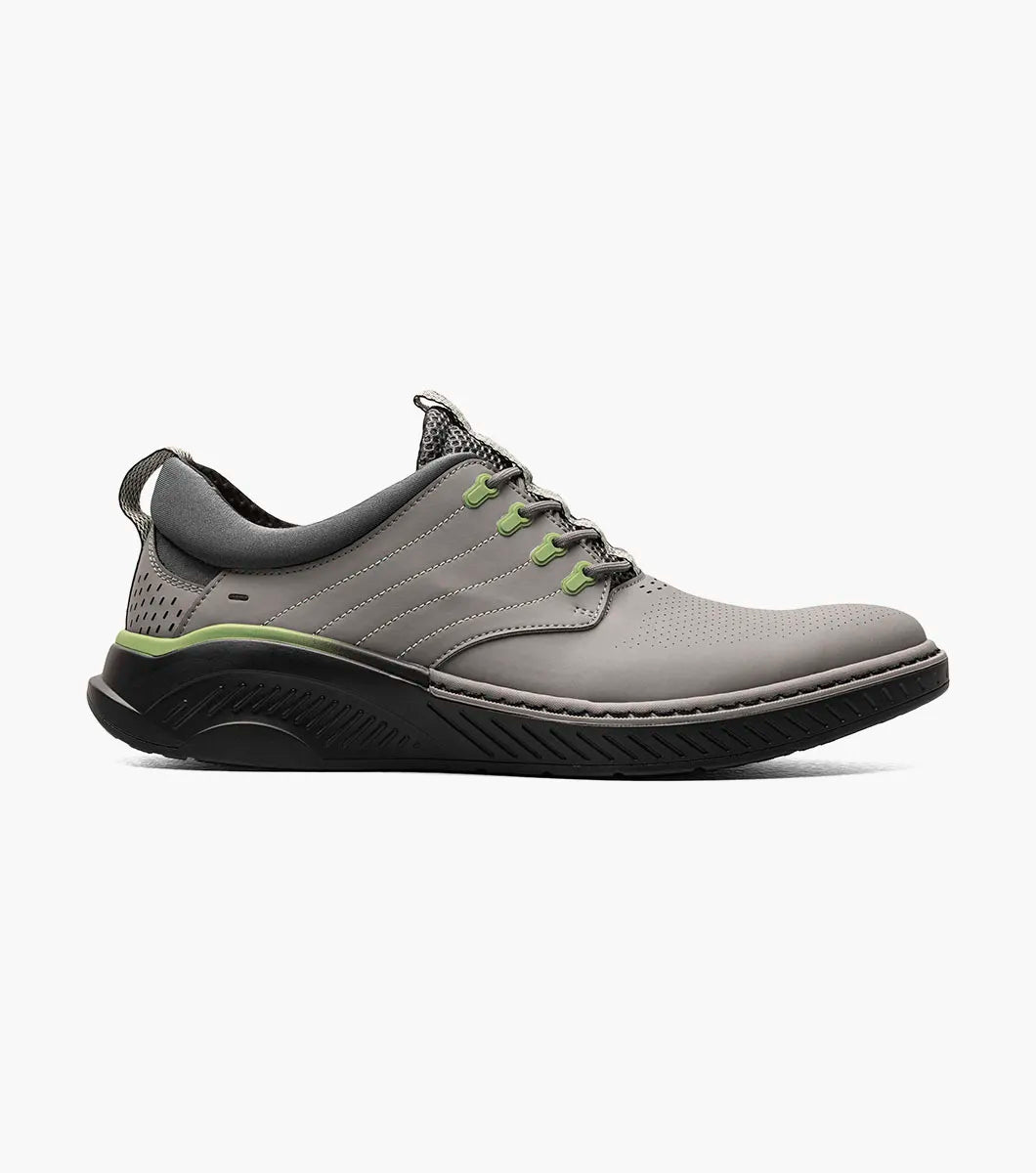 The Stacy Adams Barna Plain Toe Lace Up sneaker in gray (25594-020) features black and green accents, patterned laces, a perforated toe, removable footbed, and a textured black sole; displayed on a white background.